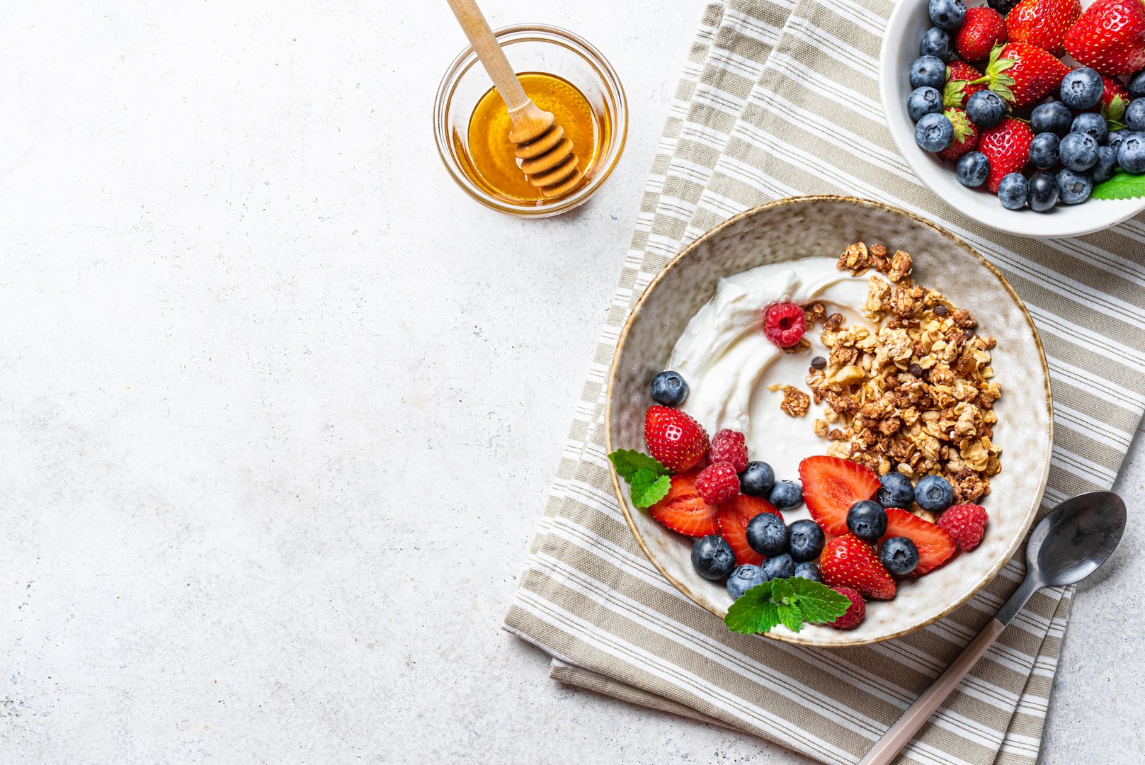 Granola bowl for healthy breakfast. Homemade granola with greek yogurt, fresh berries and honey