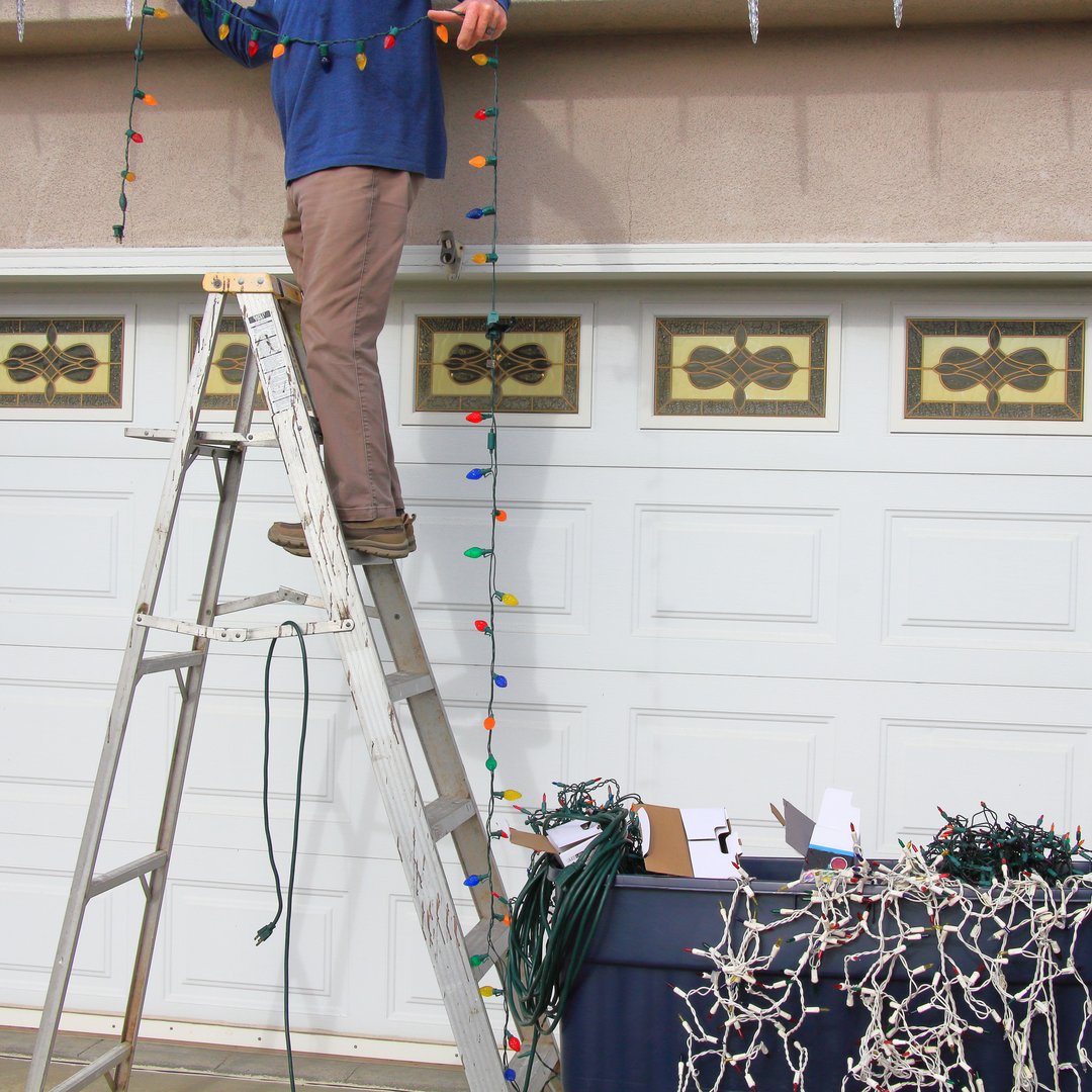 Balancing on a ladder, trying to stretch the Christmas lights along the side of the house