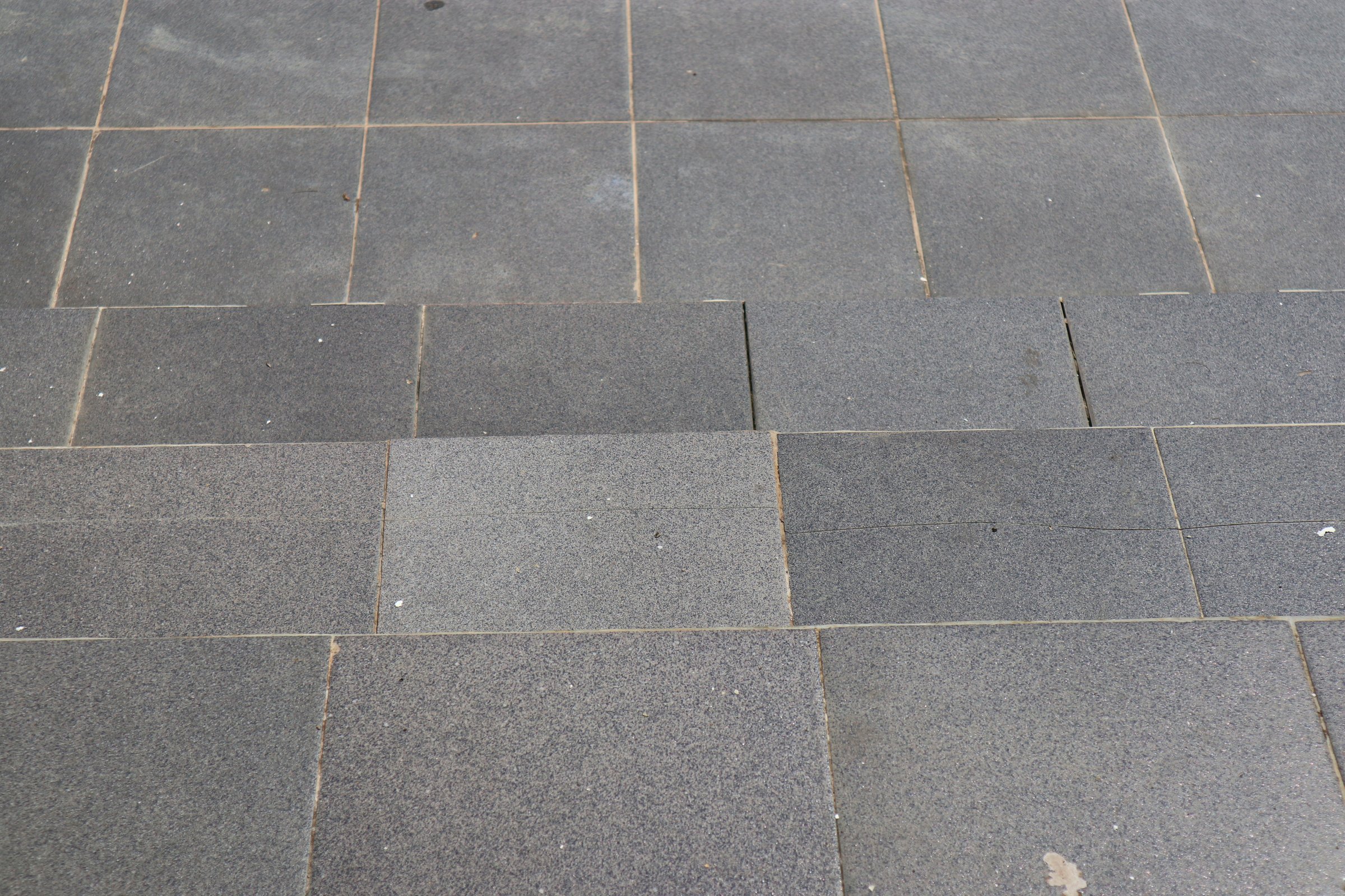 Close-up view of grey granite steps, showcasing texture and architectural detail.  Subtle variations in tone create visual interest.