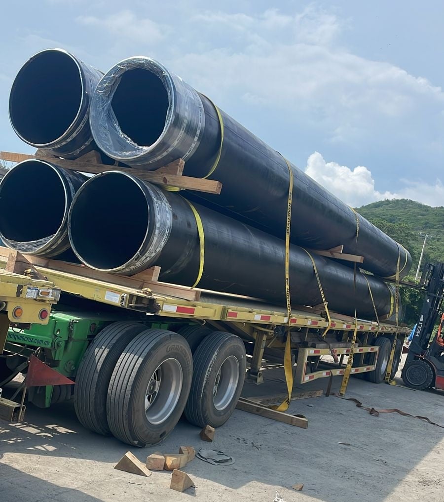 Close up of stacked metal pipes in industrial workshop.
