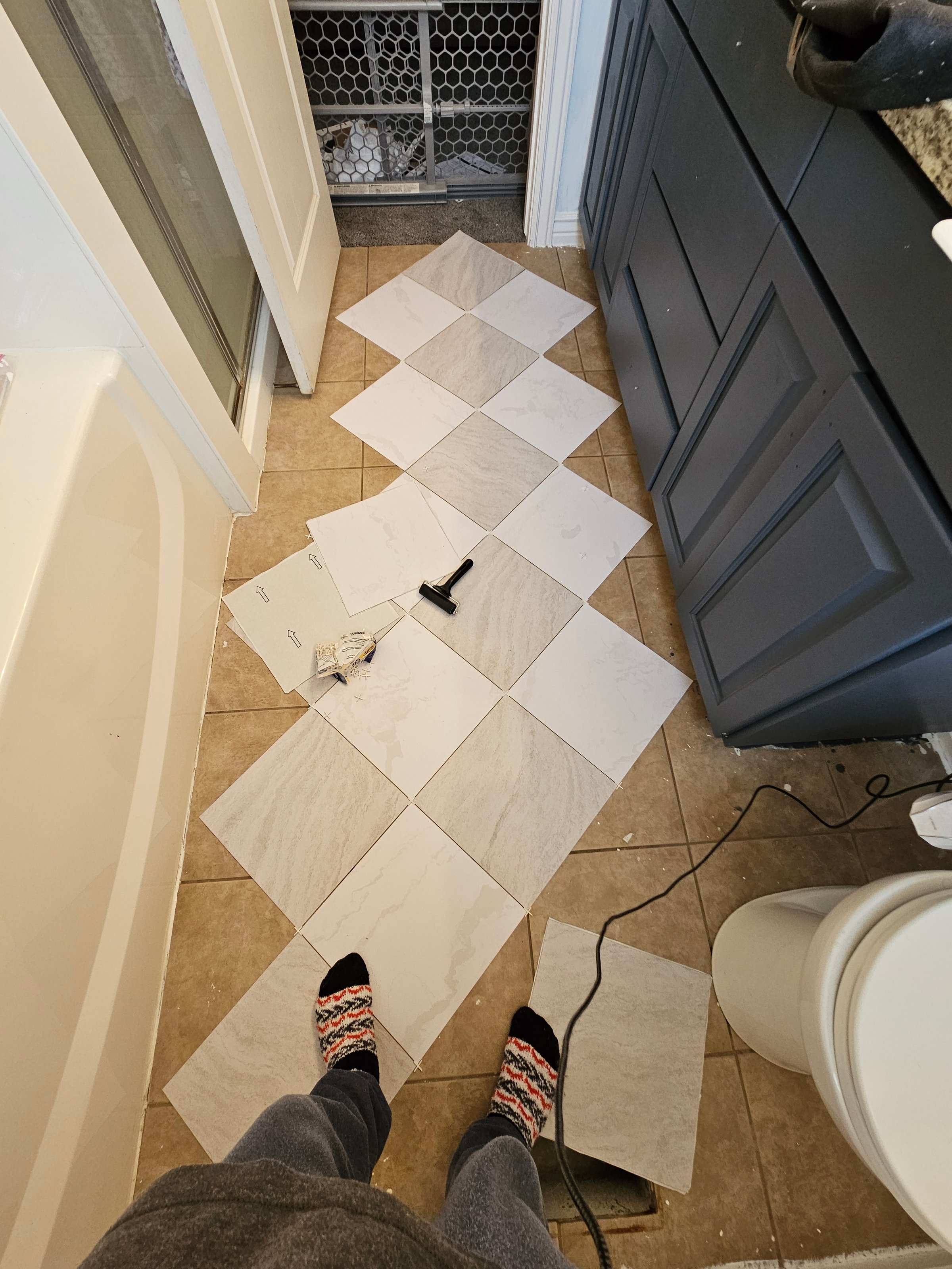 Peel-and-stick floor tiles installed in bathroom showing subtle pattern