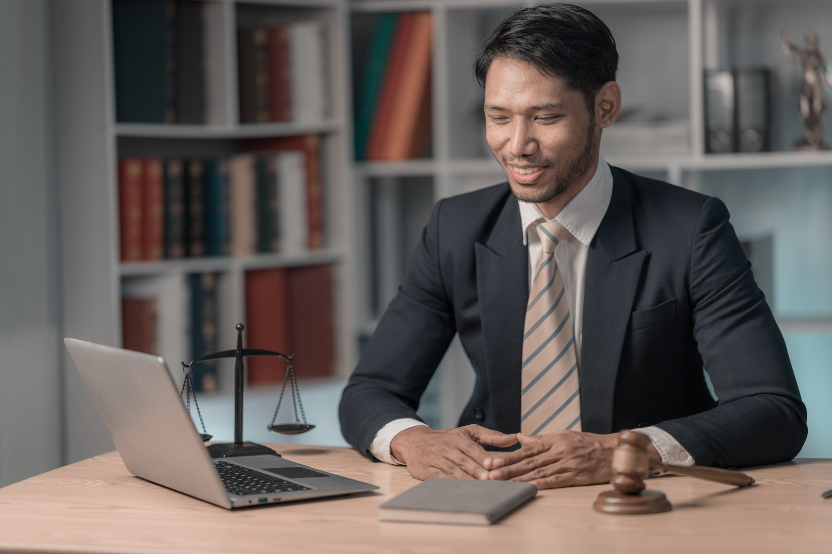 Lawyer working or reading law book working with laptop in office as legal counsel, justice and law.