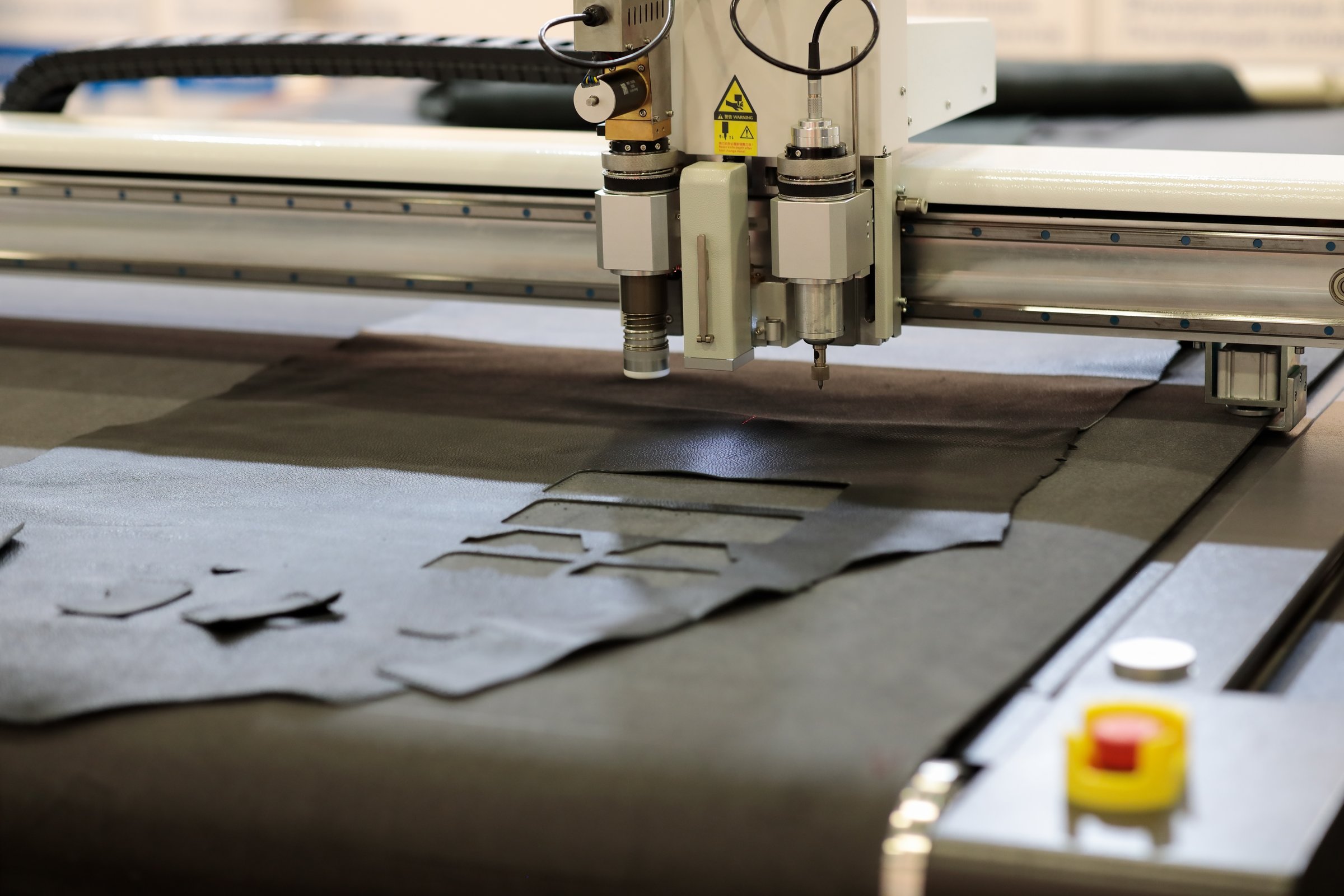 Automatic flatbed digital cutting system close up. CNC leather cutting machine. Selective focus.