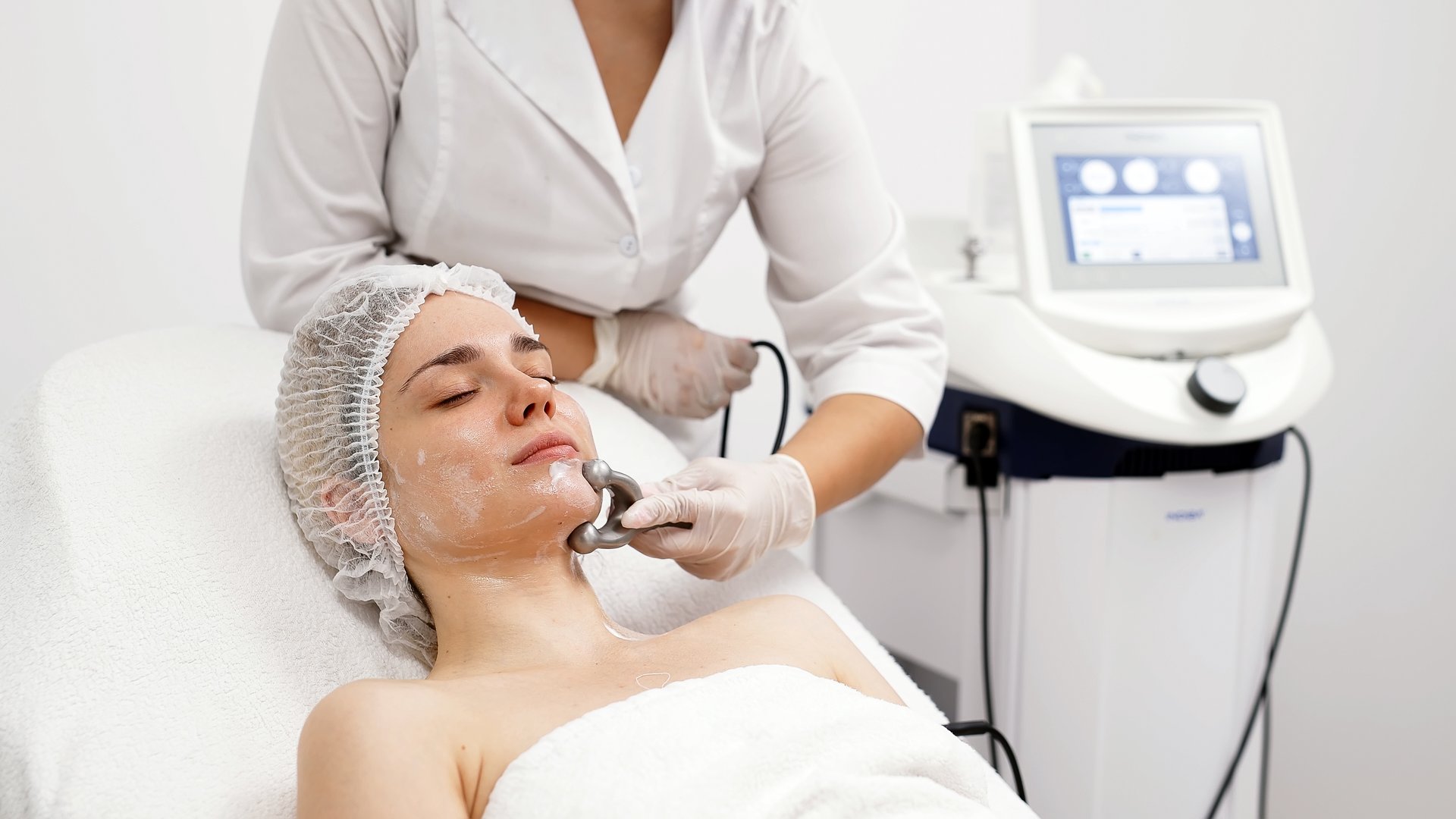 A cosmetologist performs RF lifting and ultrasound facial tightening in a modern salon. This advanced treatment rejuvenates and firms skin, perfect for showcasing effective beauty solutions.