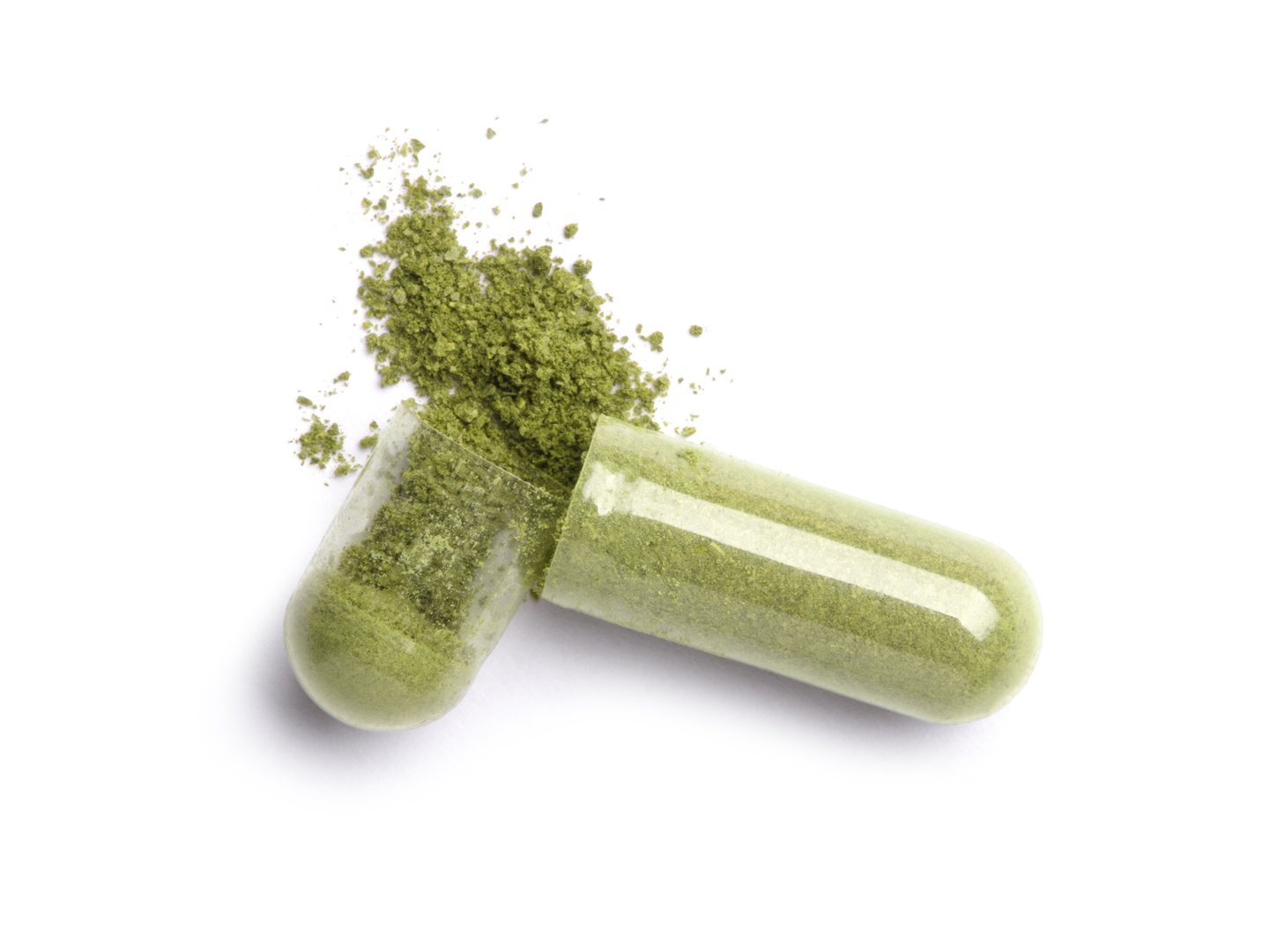 Green capsule medicine isolated on white background. Top view.