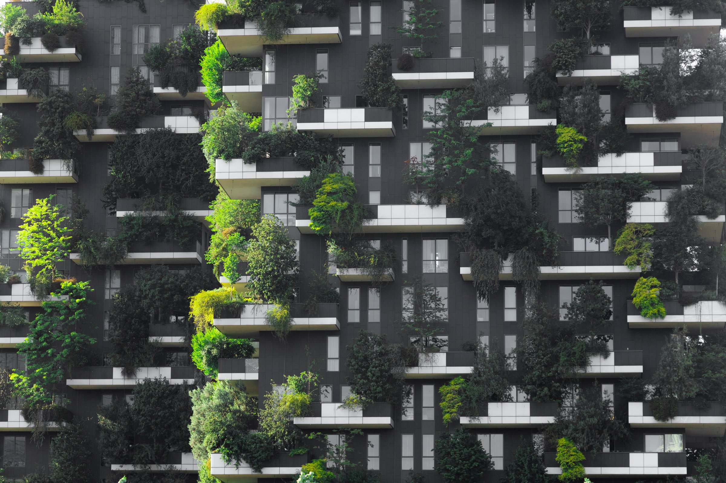 Vertical garden residential building with trees and plants adorning balconies, representing sustainable urban living and eco-friendly architecture in a cityscape setting.