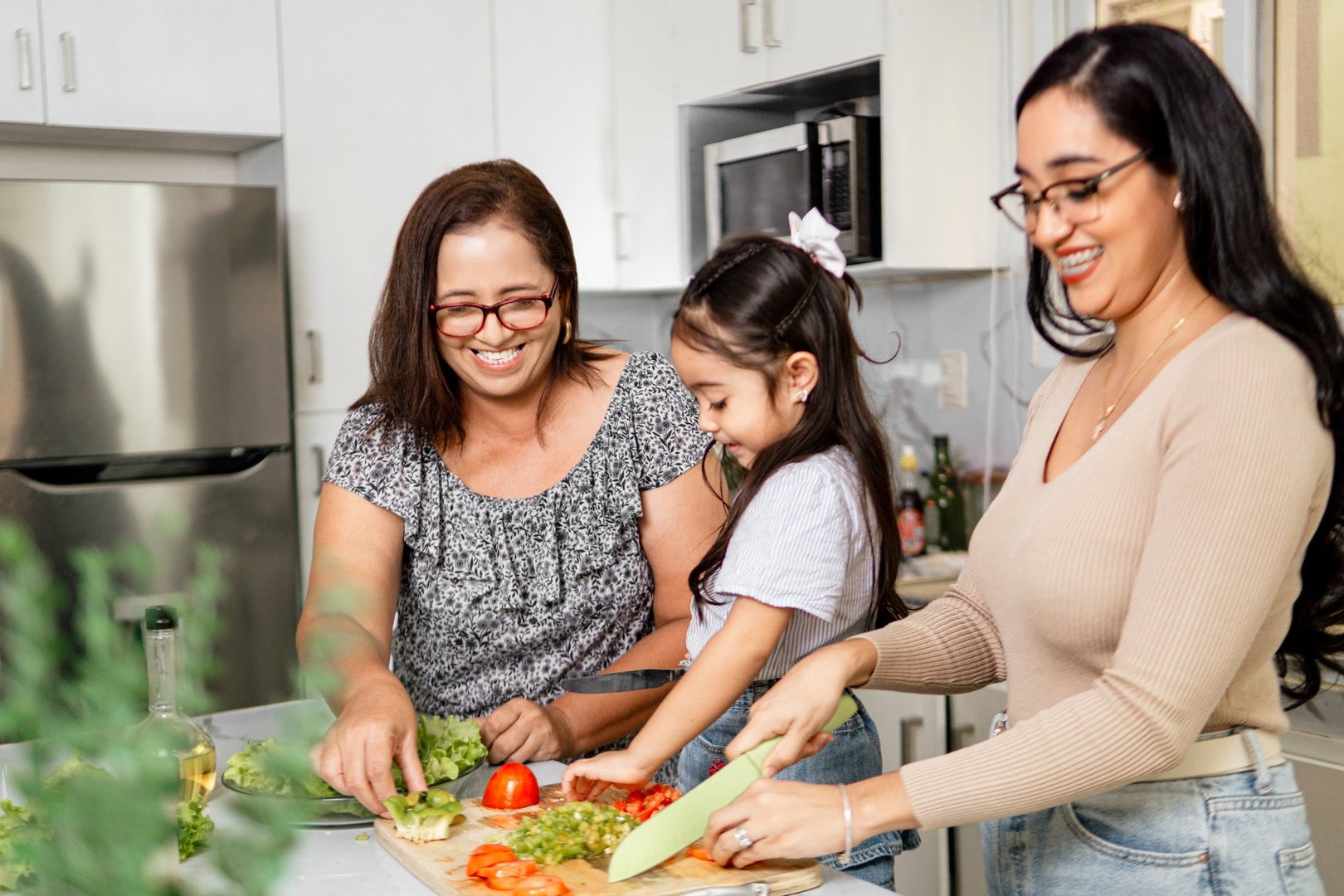 Family of three generations making a salad to the lunch. family time concept.