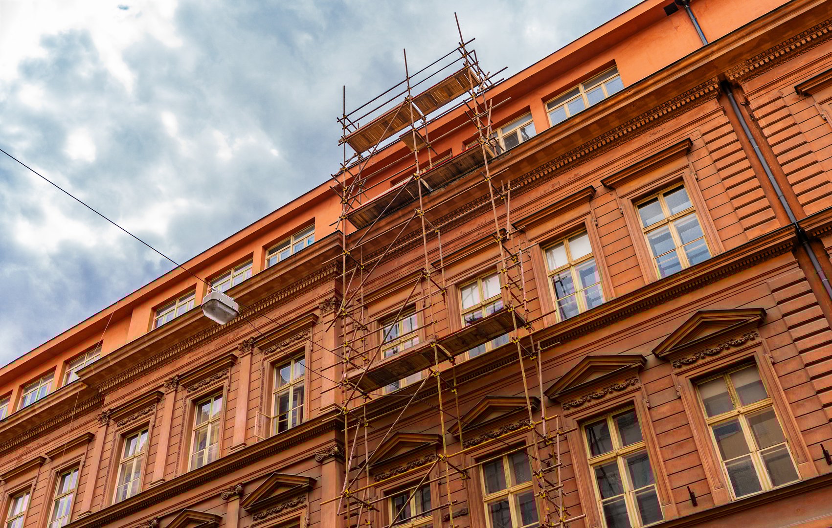 Building Facade Covered with Construction Scaffoldings.