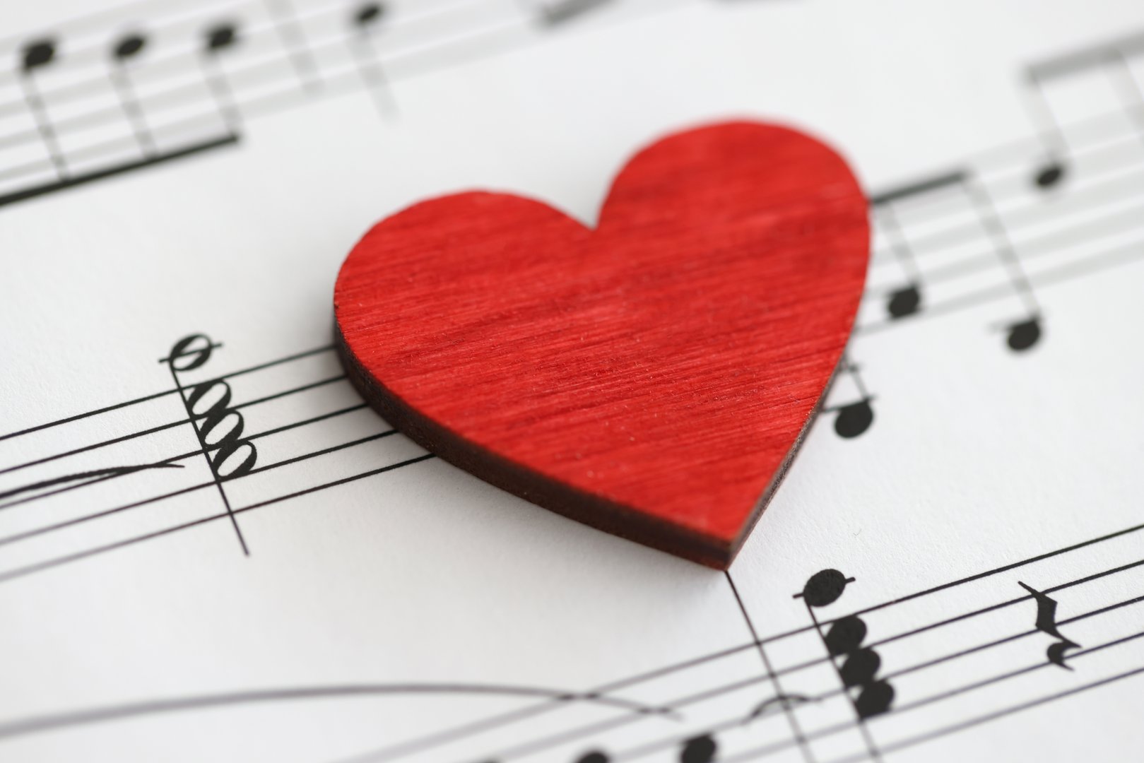 Small red wooden heart with musical notes. Love to study music concept