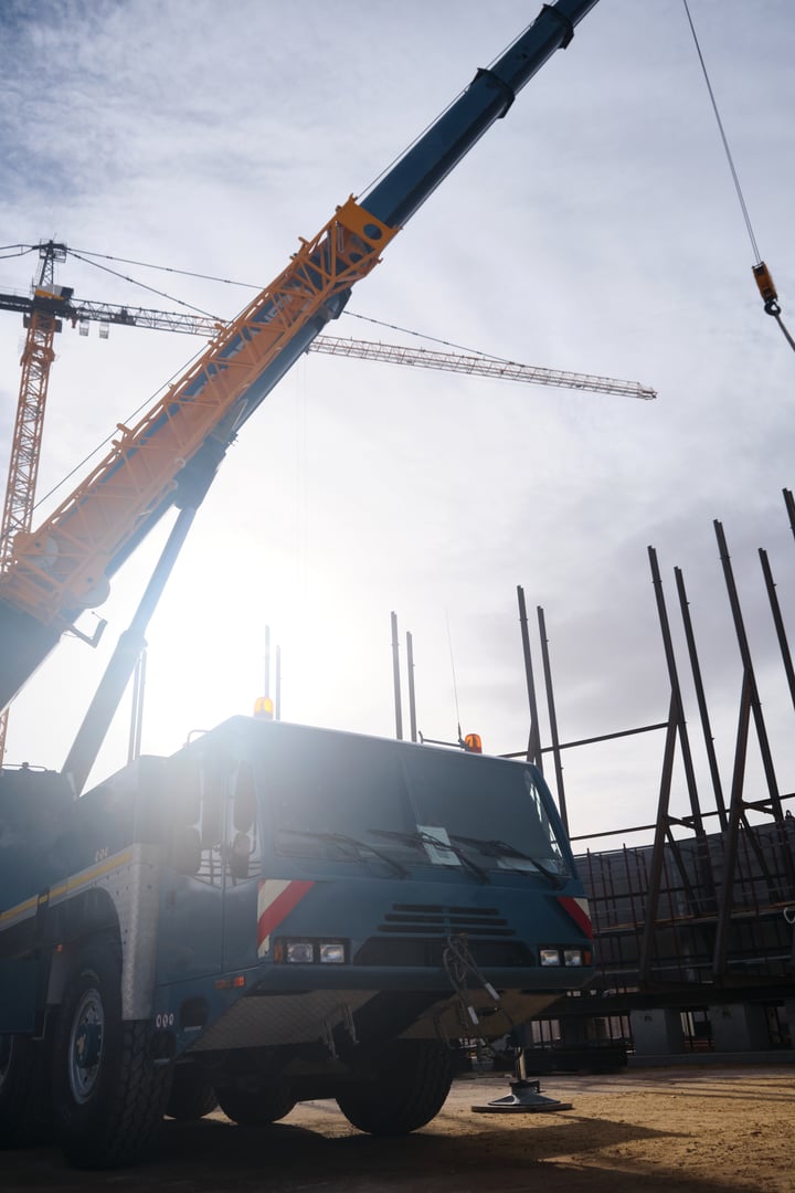 Heavy all-terrain mobile crane at construction site. Heavy lifting machinery. Car mounted crane low angle view