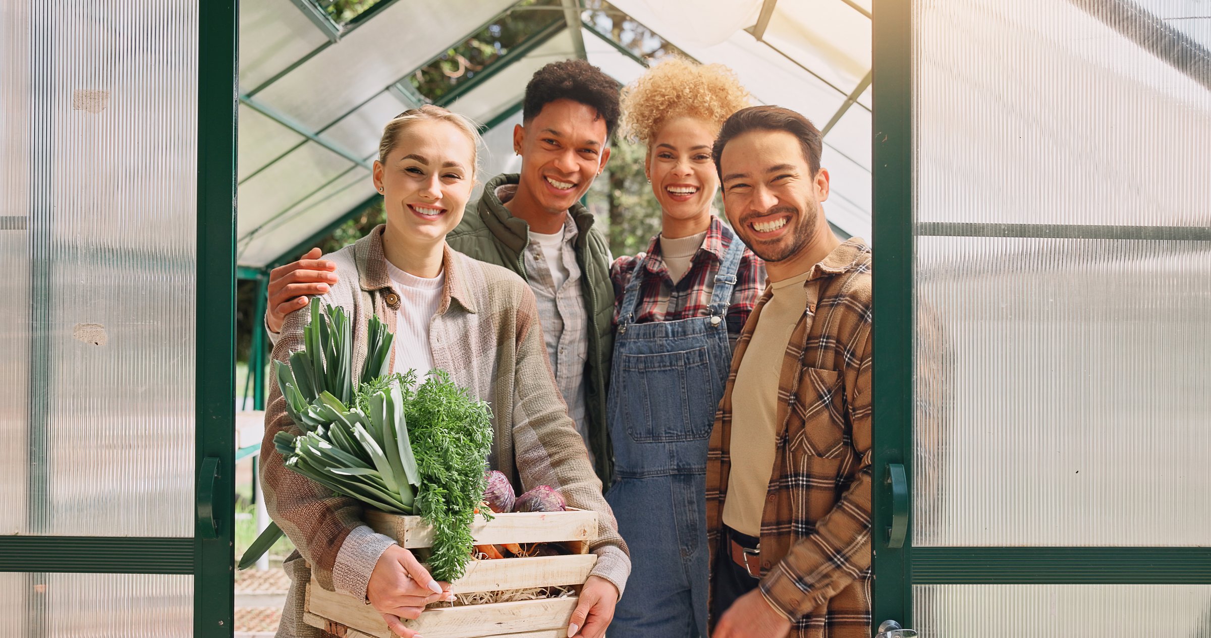 Greenhouse, farmer group and harvest portrait, people happy with crate of vegetable crops and sustainability. Community, farming and organic produce in box, eco friendly hobby and food production