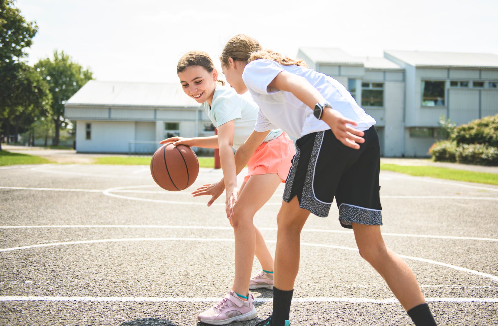 The two childs girls in sportswear playing basketball game