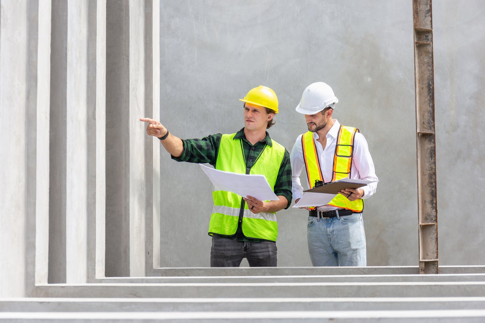 Engineer and foreman worker checking project at precast factory site, Engineer and builders in hardhats discussing on construction site