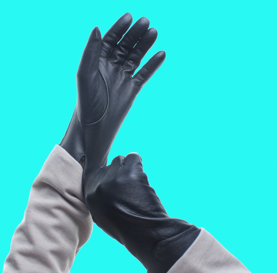 Female hands wearing leather gloves isolated on blue background."n