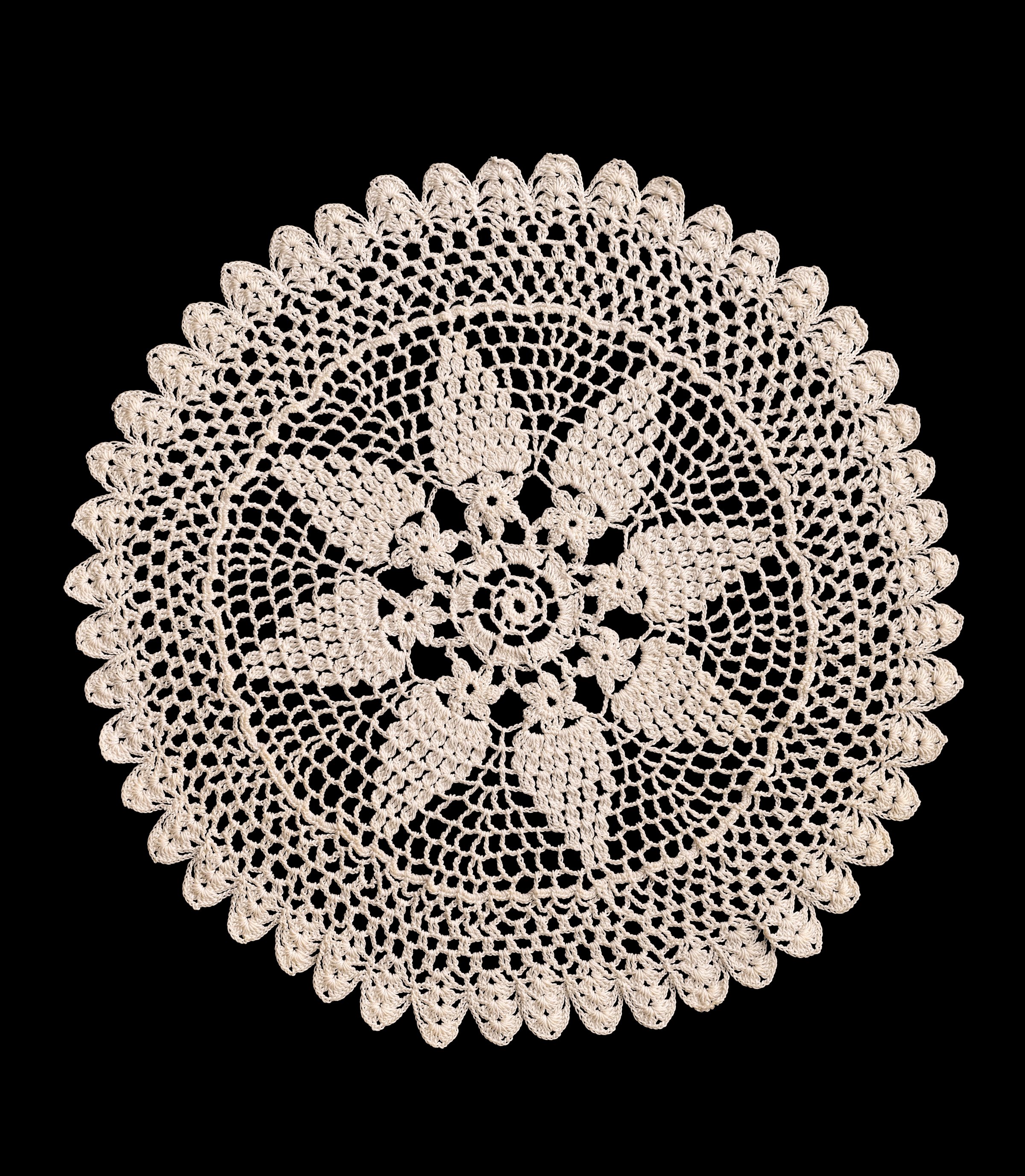 Round beige crochet doily isolated cutout on black