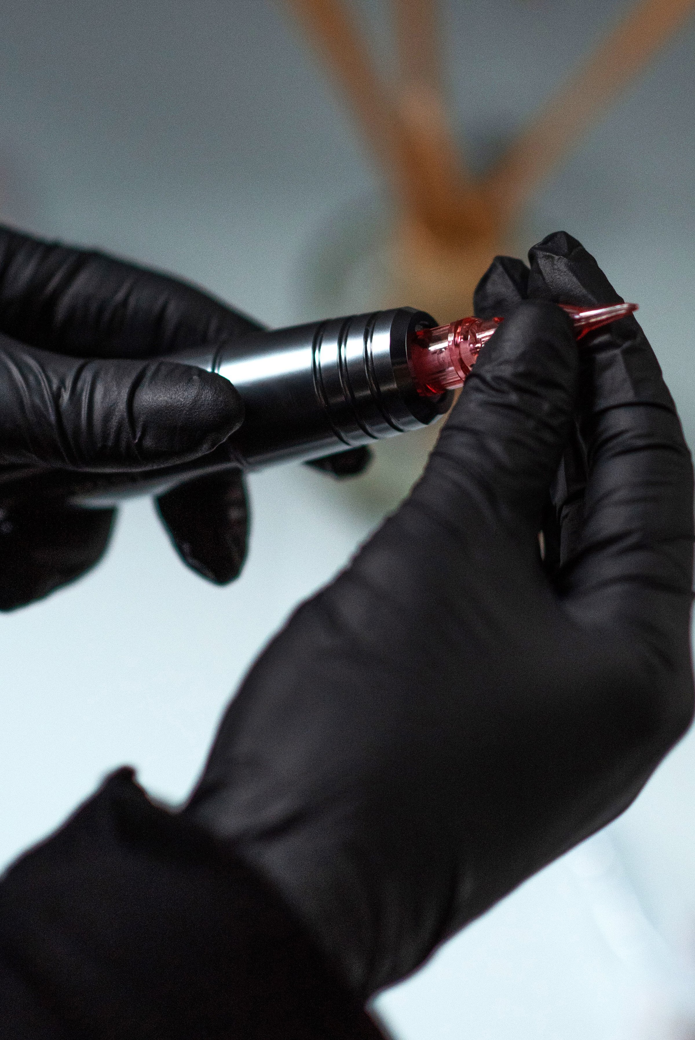 Tattoo artist inserts cartridge into machine
