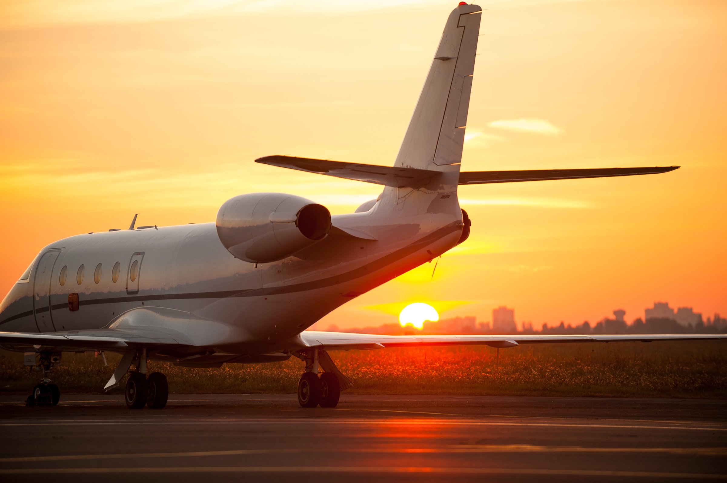Airplane landing in airport with sunset in the background