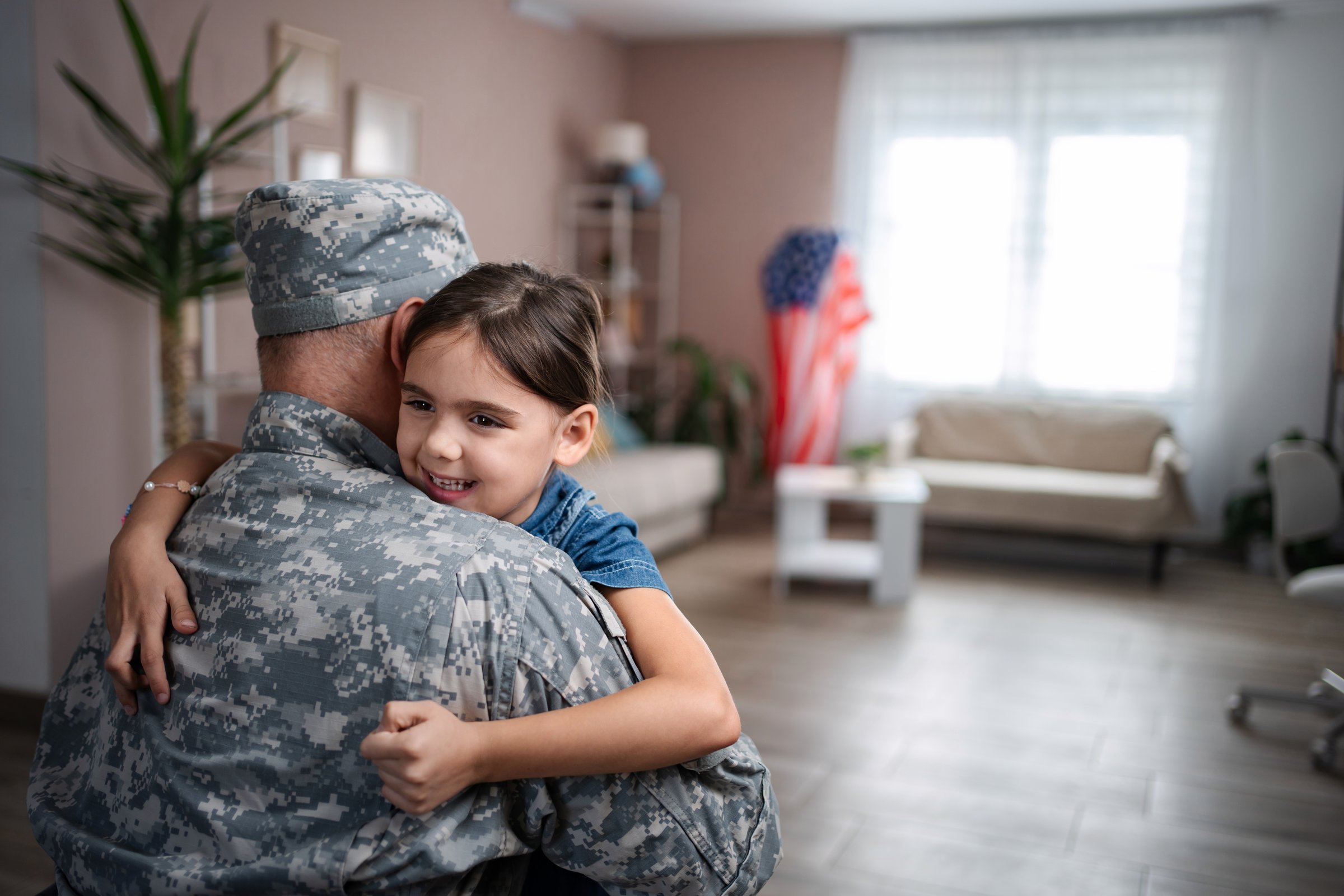 Soldier dad embracing his little girl after returning home from military service