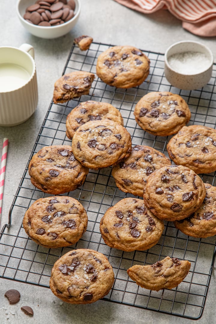 Homemade American brown butter chewy, fluffy and soft chocolate chip cookies on a cooling rack with salt and milk. Biscuits for children. Selective focus.