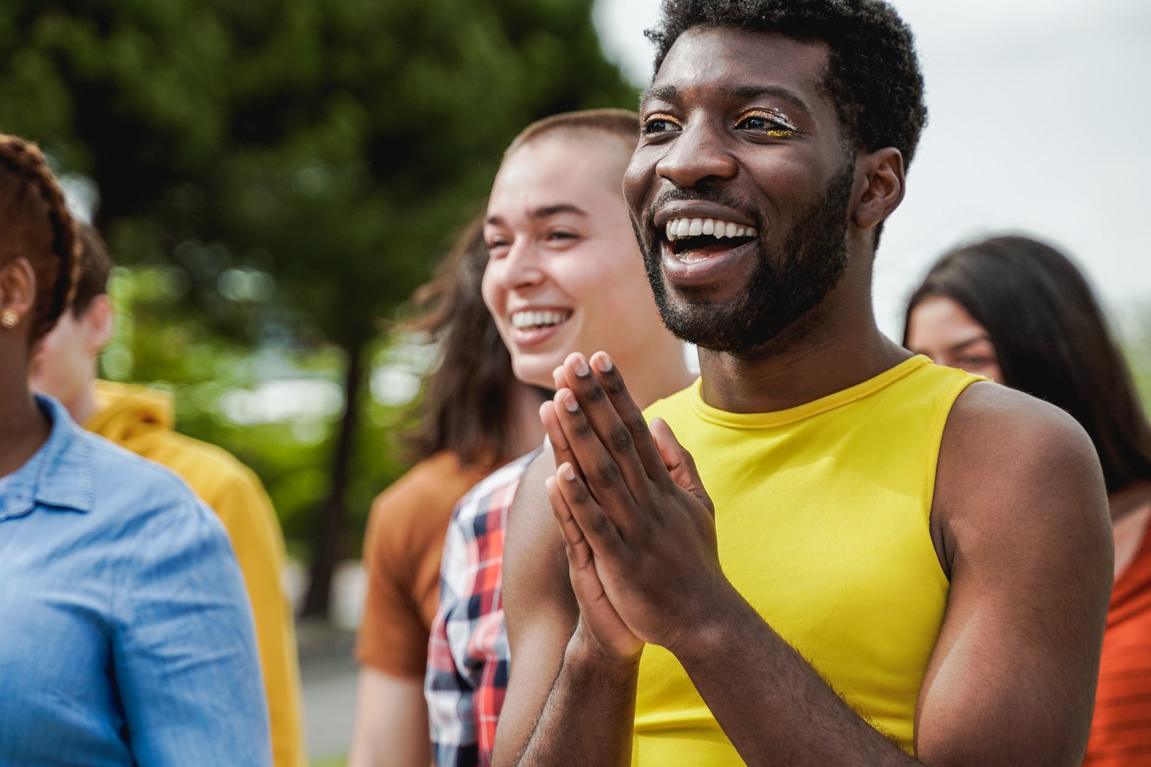 Multiethnic diverse people celebrating together outdoor at pride event - Focus on gay african man with make-up
