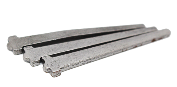 Three iron railway spikes laid side by side on a white background.