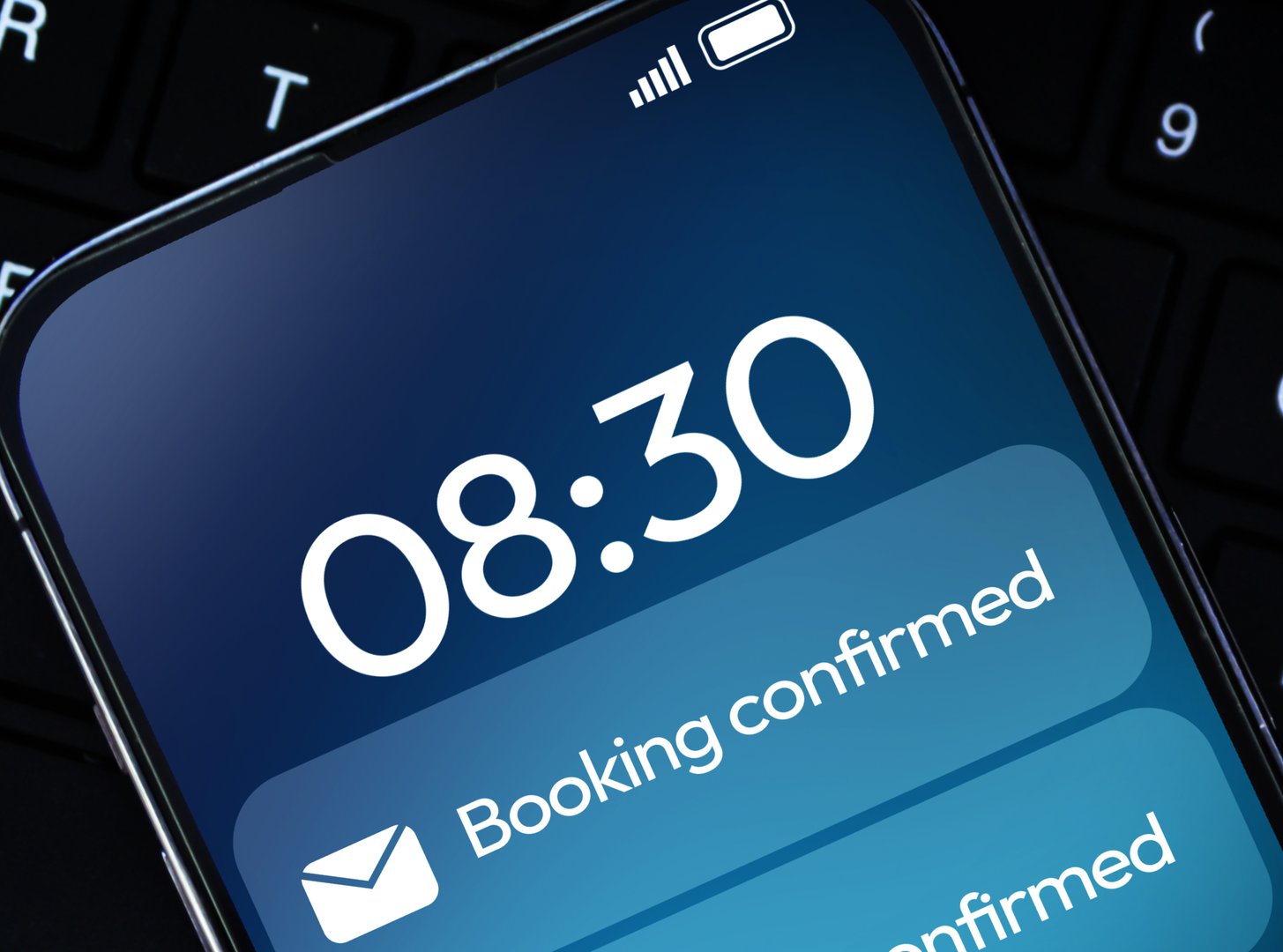 Booking Confirmation notification on mobile lock screen with keyboard in the backdrop. Online booking message notification background