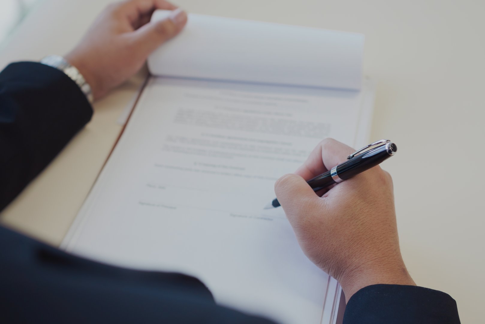 Businessman reviewing and signing official documents at a desk, representing contract approval, legal agreement, paperwork, business negotiation, and professional responsibility.