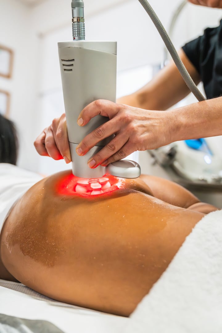 Woman getting a deep physioactive massage on her body using a modern machine with rotating heads and red light therapy