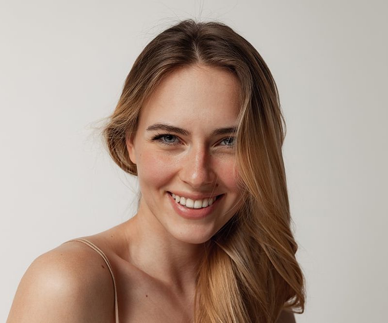 Patient displaying perfect smile after cosmetic dentistry treatment including teeth whitening and dental veneers