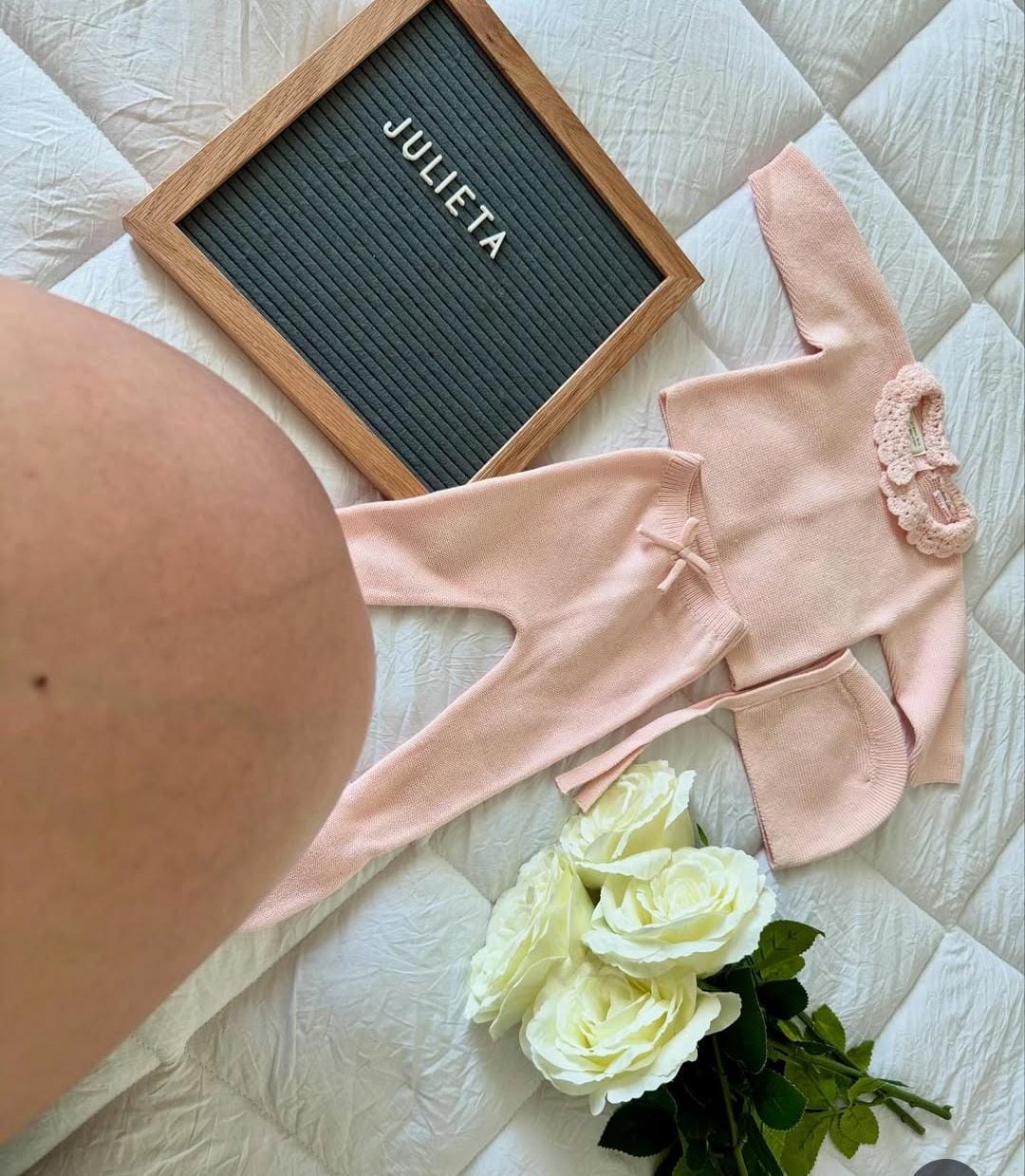 Niña modelando hermoso vestido rosa de la Colección JULIETA sosteniendo pizarrón con flores blancas en ambiente natural y delicado