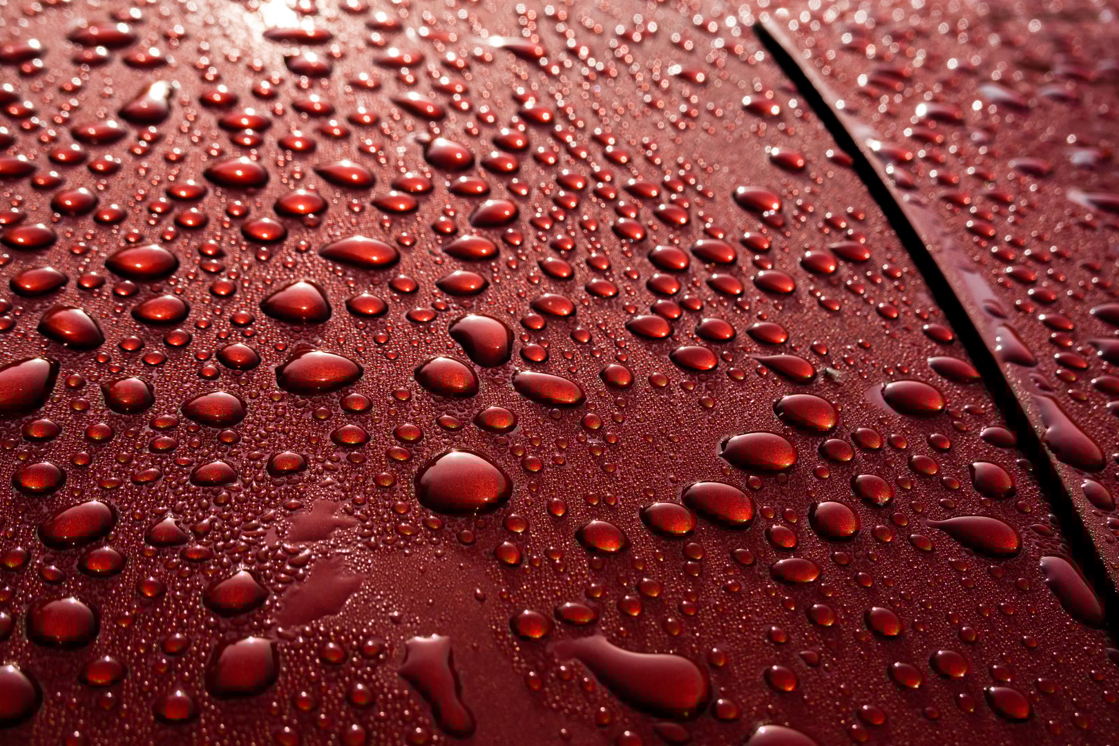 Wet red car after rain - reflection s and texture. Beads of water concept, urban poetry