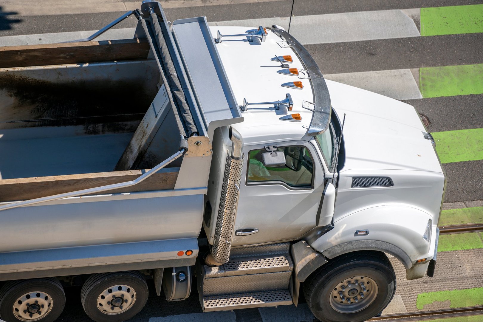 Tip truck hauling bulk cargo through city roads