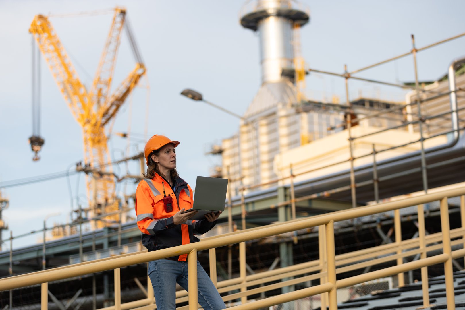 The confident Female oil engineer working at Oil refinery outdoors. Engineer holding oil and gas production checklist. Blue-collar Worker of Oil and Gas industry concepts.