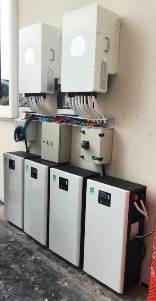 Wall-mounted electrical equipment setup with wiring and control boxes, featuring several large units and cables.