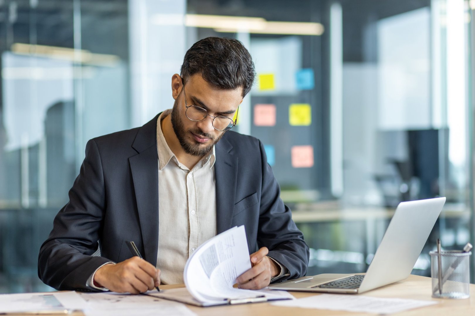 Professional in office signs contracts with focused attention and dedication. Business meeting atmosphere with documents. Depicts business, office, contract, work.