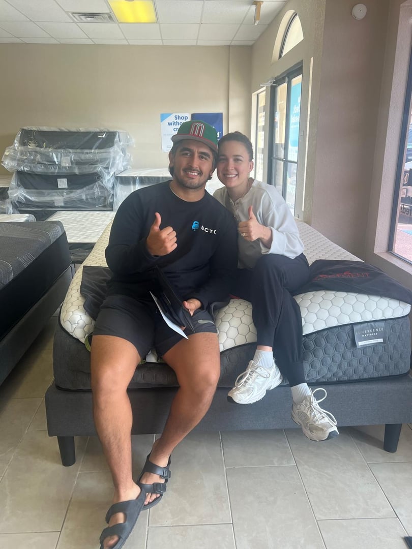 Happy couple shopping for mattresses