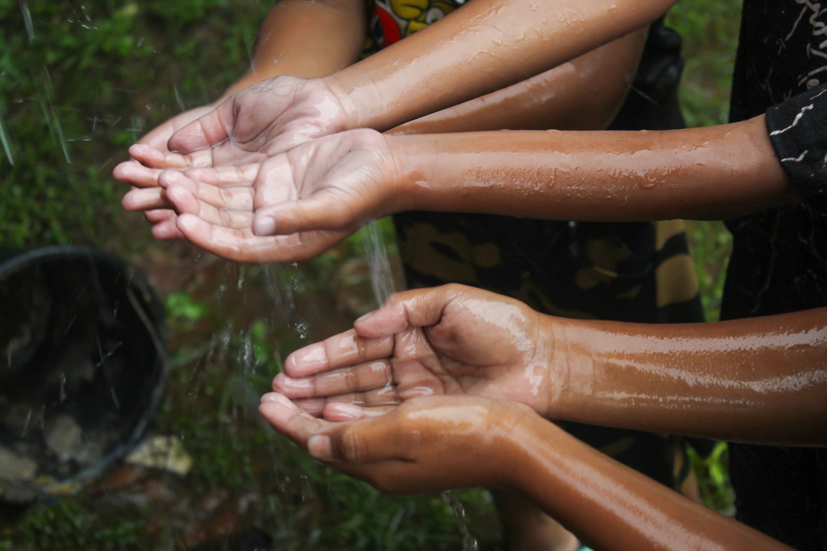 hands with splashes of falling rainwater