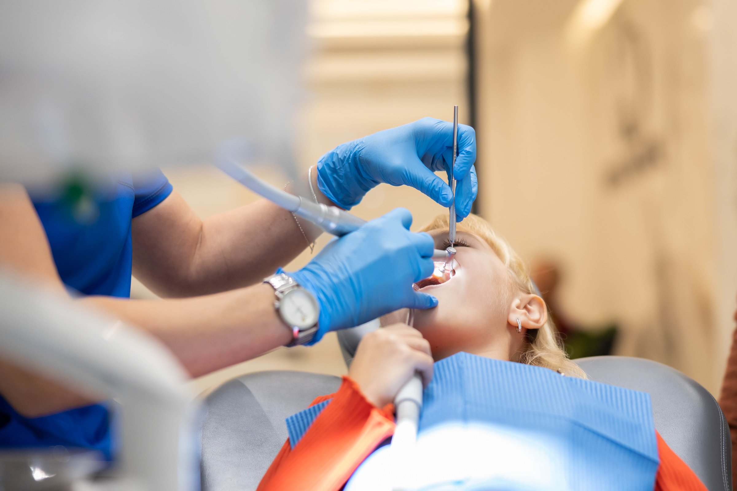 A professional dentist provides high-quality dental care to a child, utilizing specialized tools and equipment in a well-equipped modern dental clinic setting.