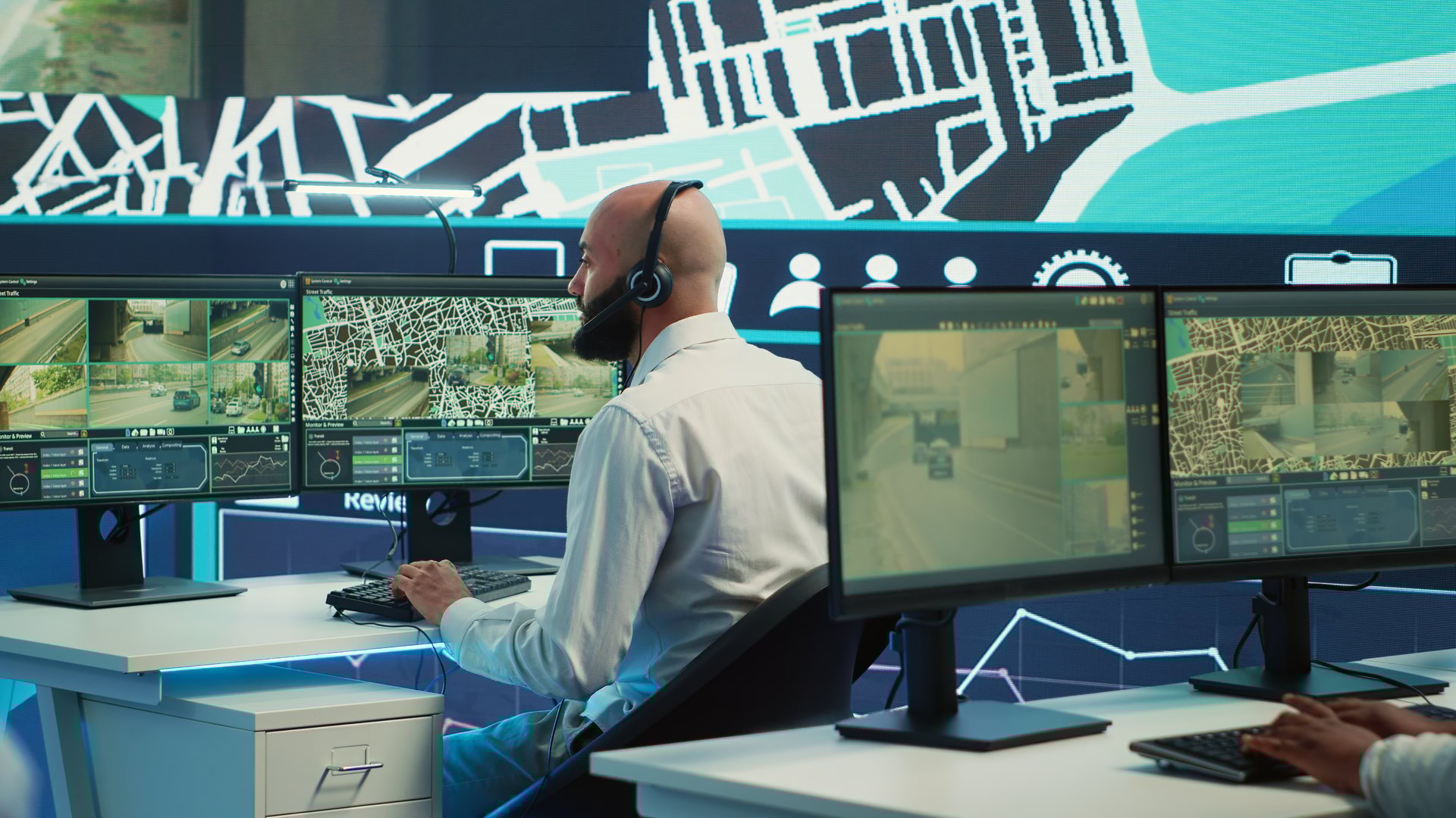 Diverse employees following the delivery track through city traffic, offering directions for less crowded street routes to ship cargo. Operators managing order tracking complains. Camera A.