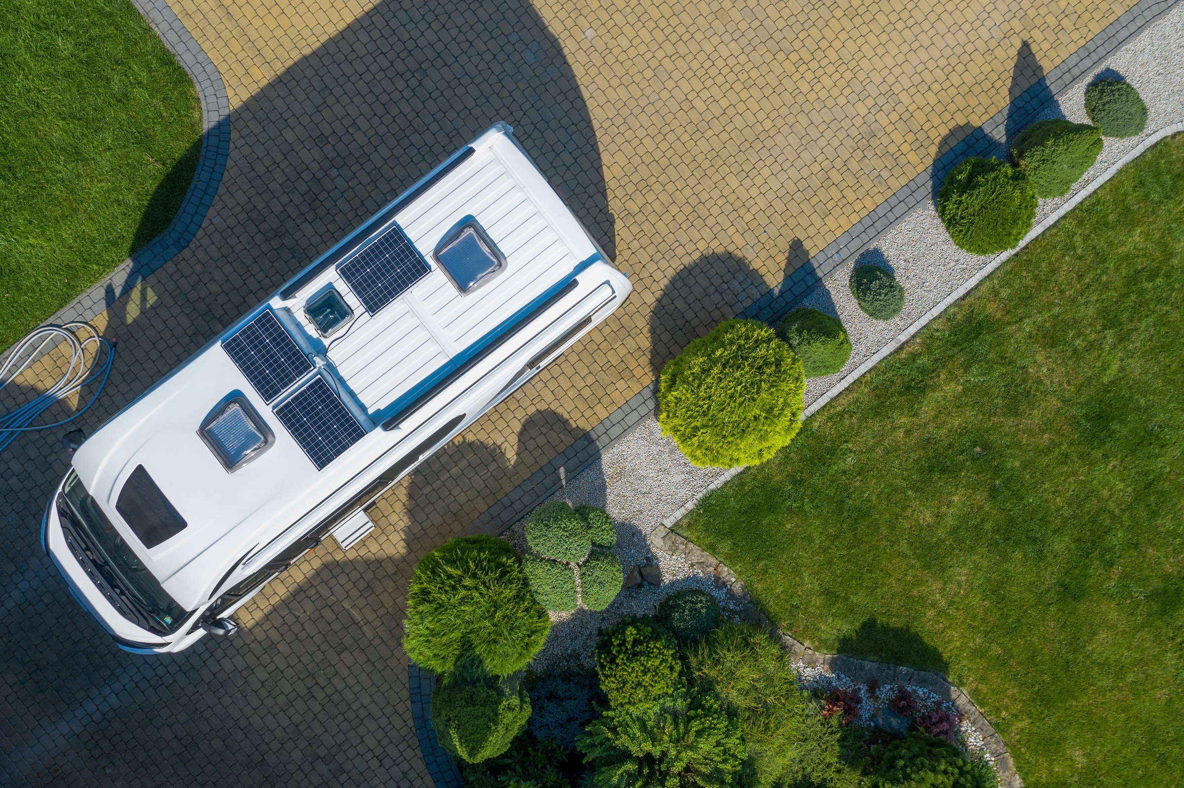 Brand New Class B Camper Van with Solar Panels Installed on Residential Driveway. New Recreational Vehicle Purchase Theme.