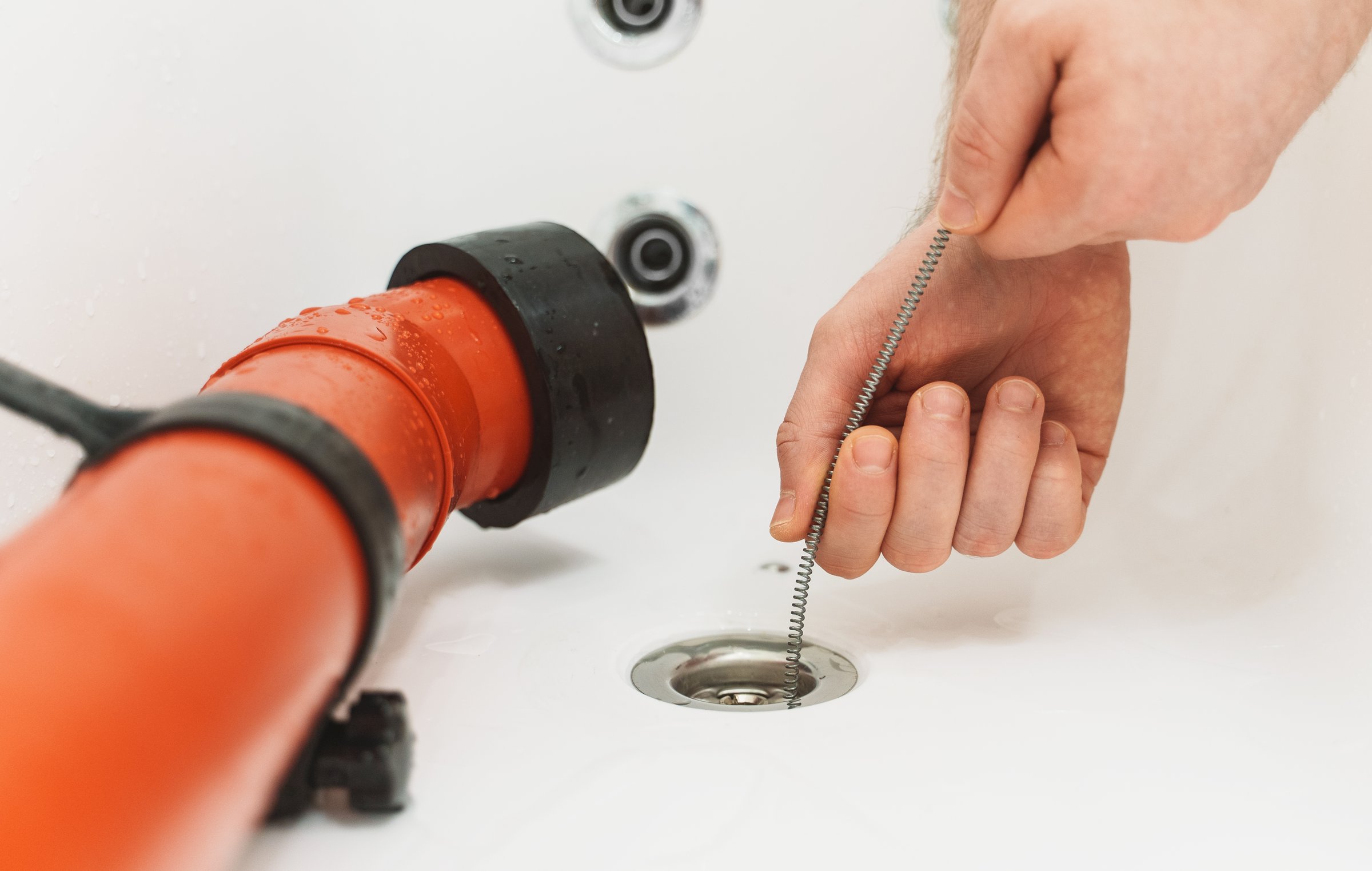 Plumber unclogging bathtub drain