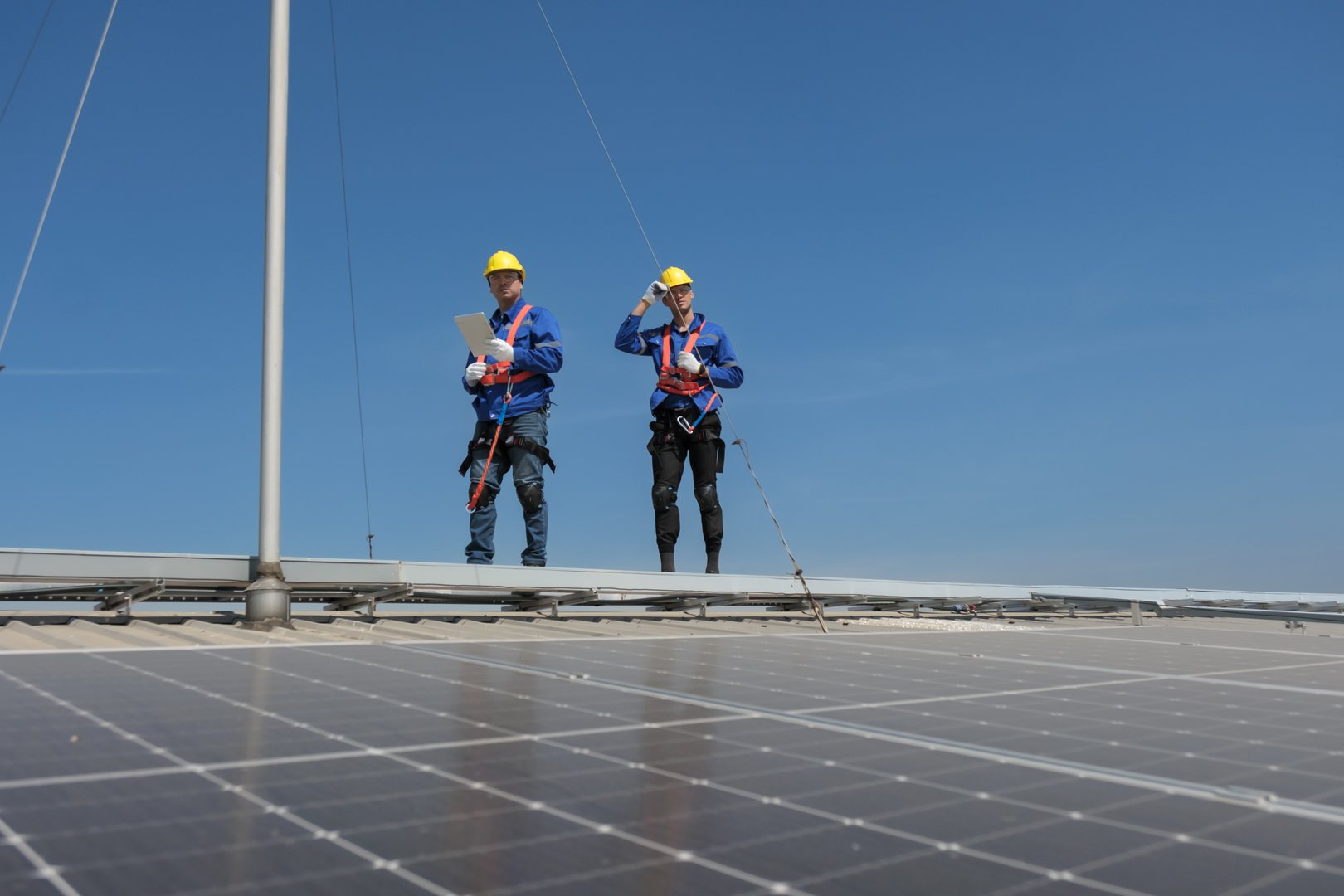 Engineers or workers install and inspect solar cell on the roof of the factory.