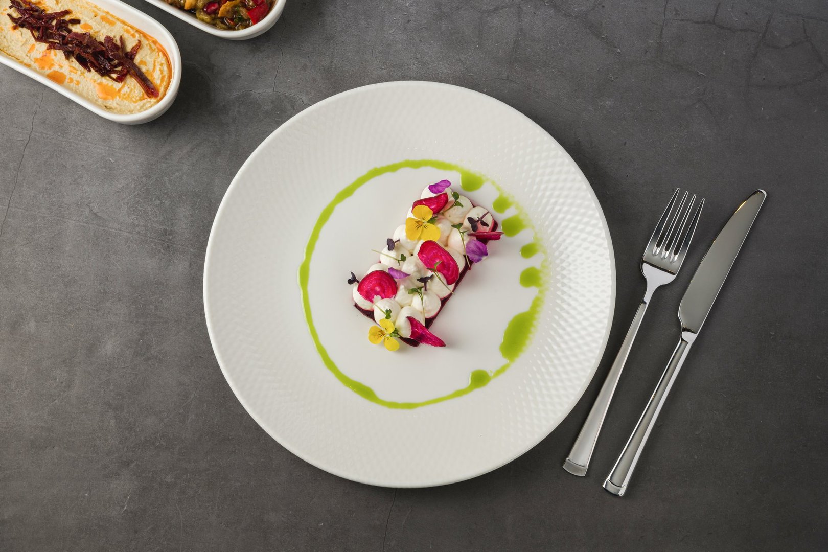 Colorful beetroot slices with goat cheese, garnished with edible flowers