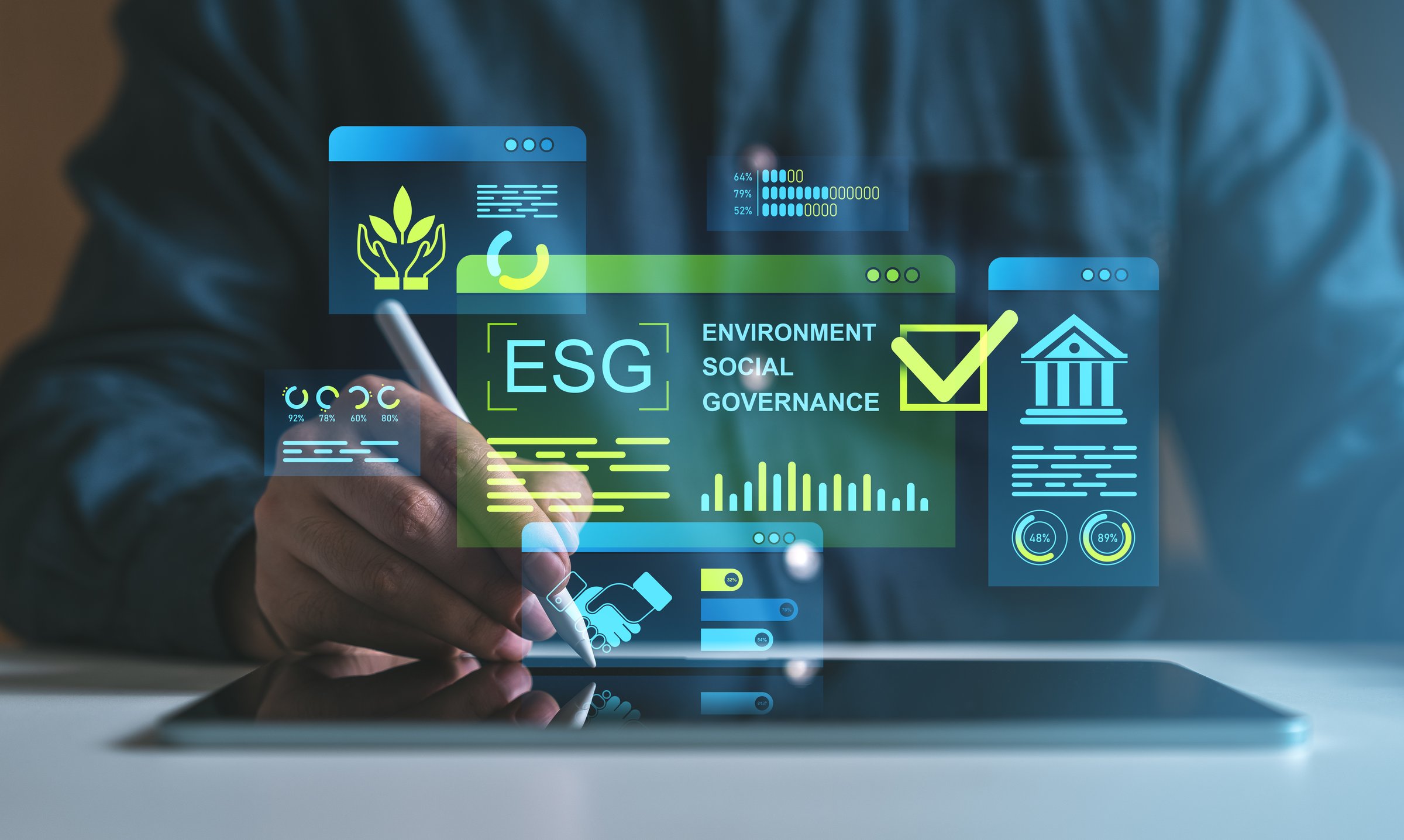 Hand using stylus on tablet with holographic ESG icons, environmental and business growth data, futuristic blue-green background, concept of strategy