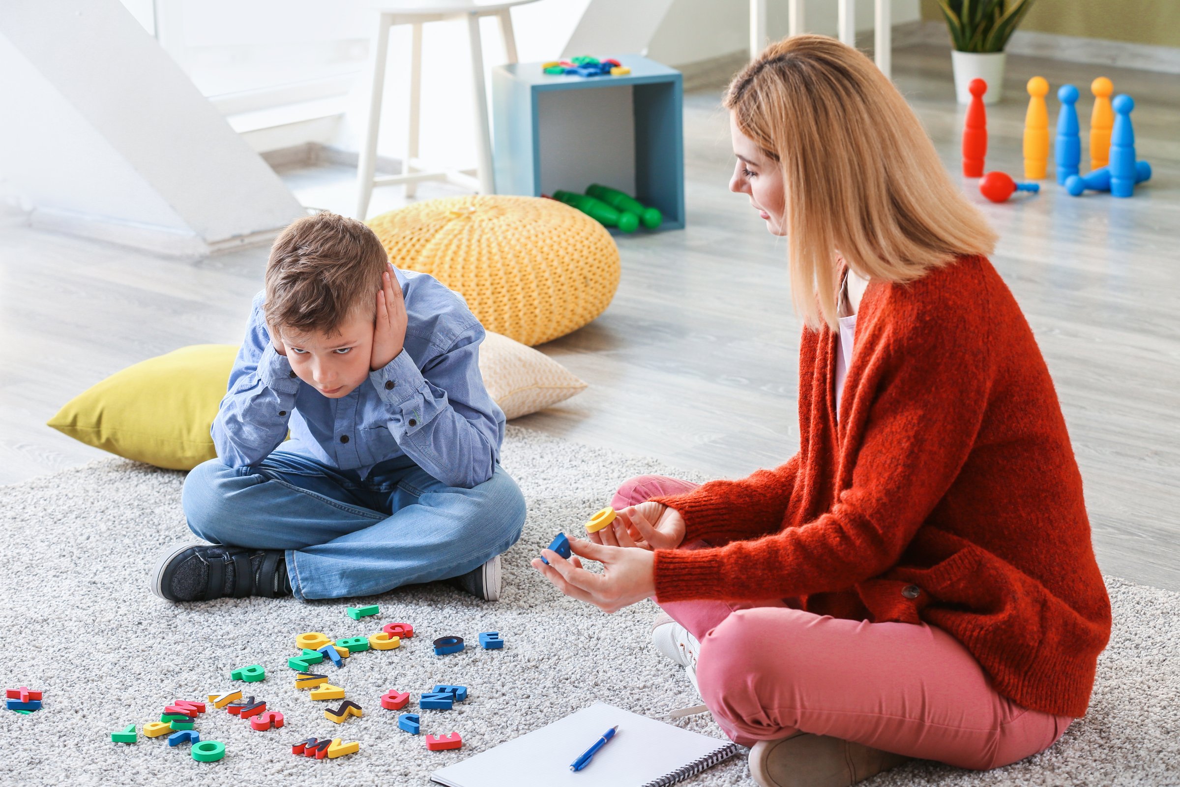 Psychology, woman and girl with dolls, talk and happy with clipboard for emotional assessment on floor. Person, therapist and child with toys, playful and checklist for test at mental health clinic