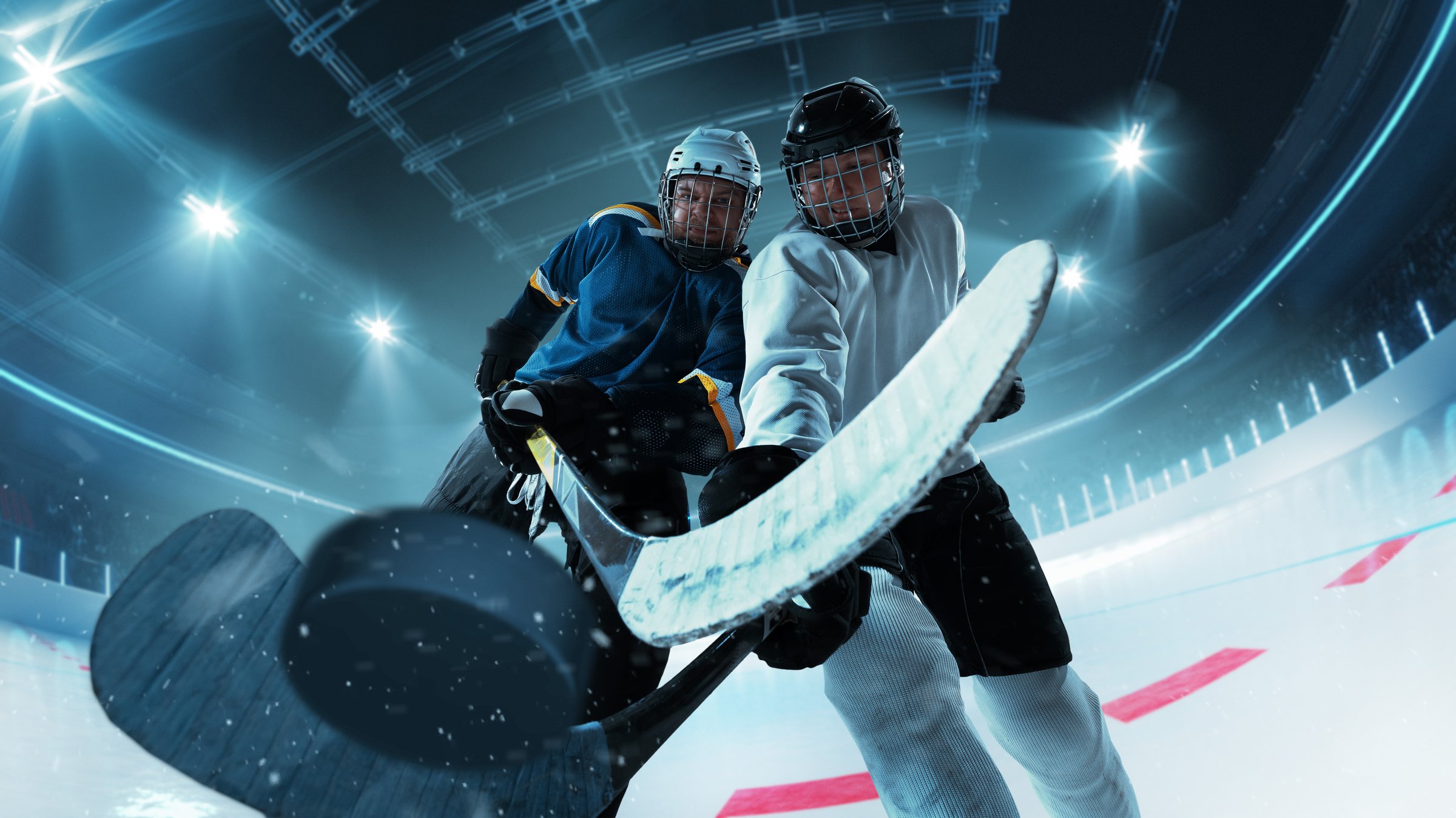 Dramatic close-up of two hockey players vying for puck control with intense determination on 3D ice rink. Concept of professional sports, fast-paced competition, skill and control