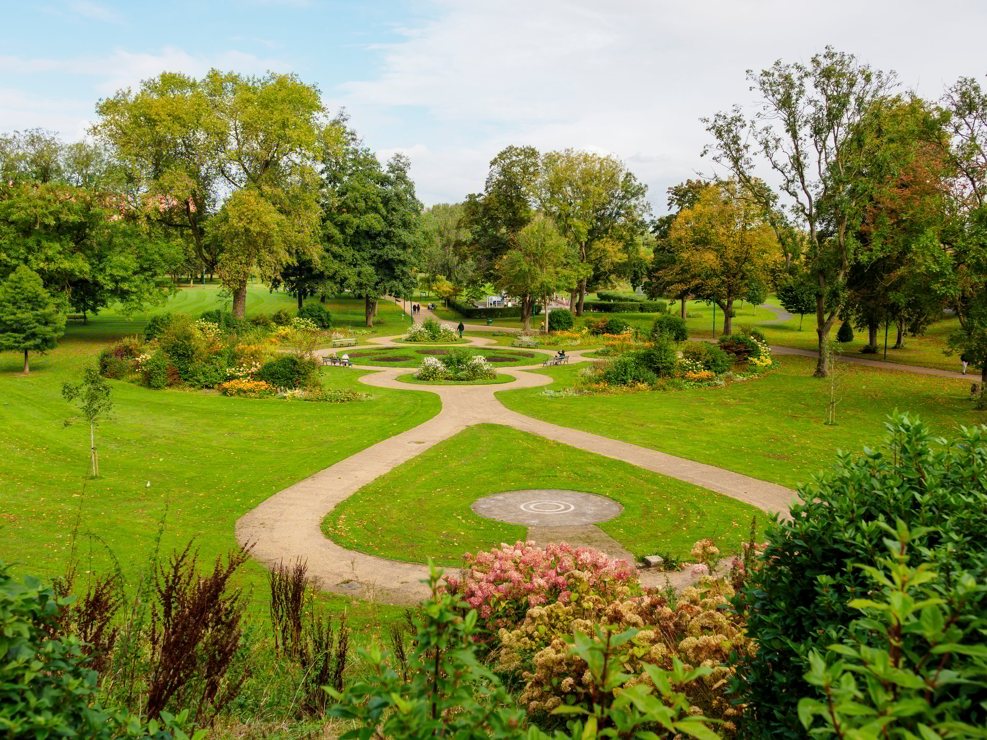 Peel park Salford. Beautiful garden park with winding pathways, lush greenery, and vibrant flowers.