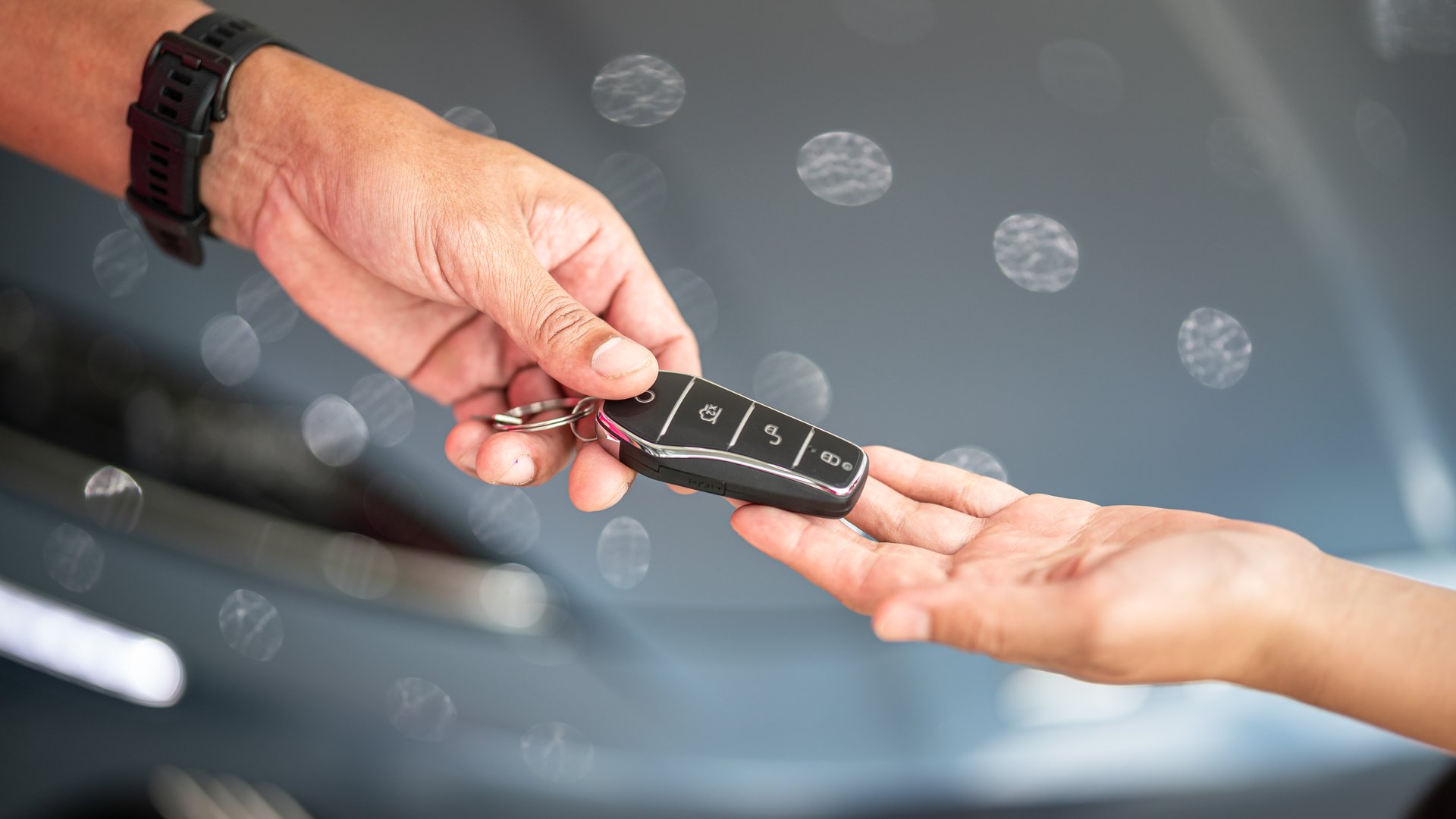 Action of human hands are giving and taking a car key. Buying the new car or car rental business concept scene, Close-up and selective focus at the object.