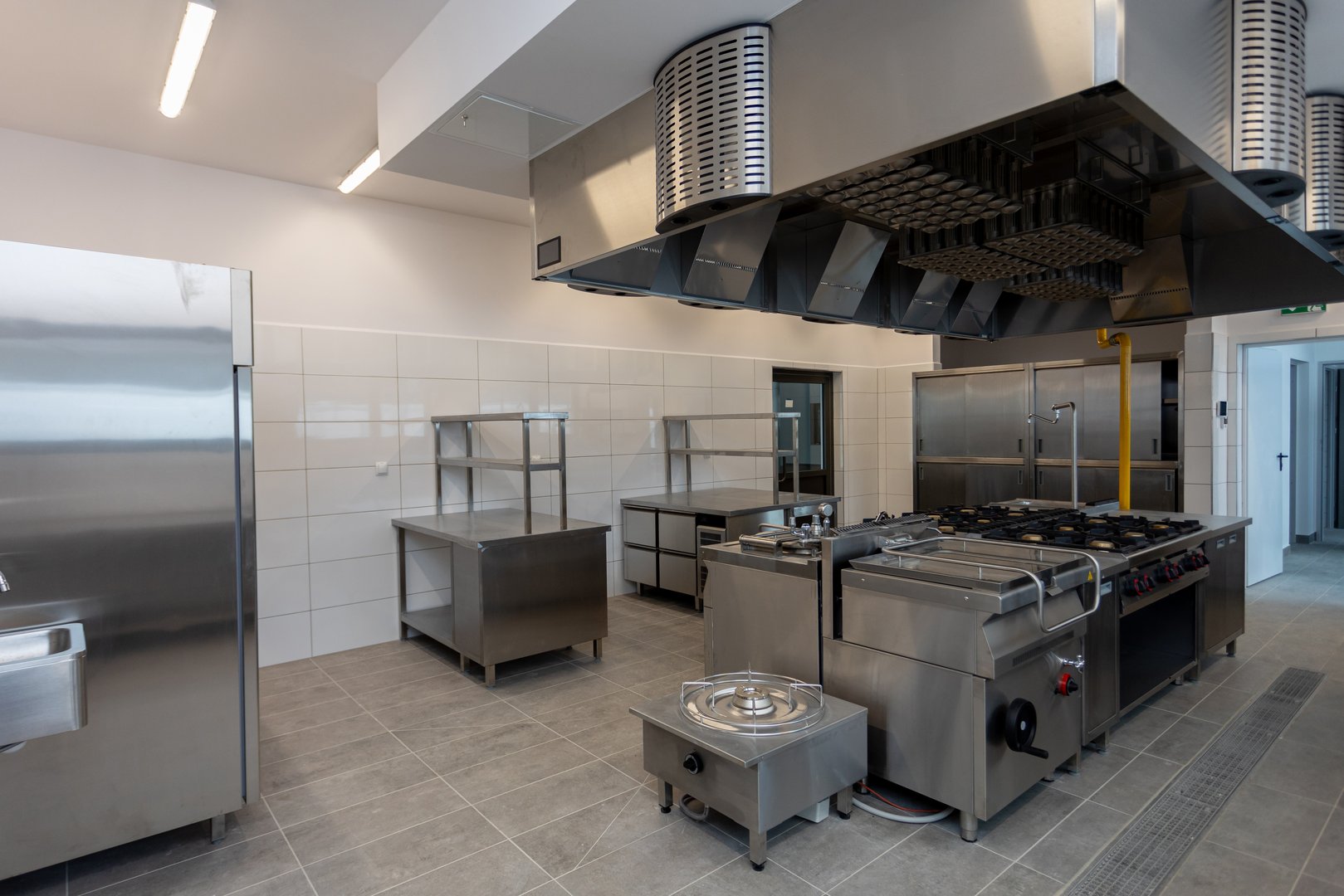 A spacious, modern kitchen featuring top stainless steel appliances and professional cooking equipment, ideal for chefs