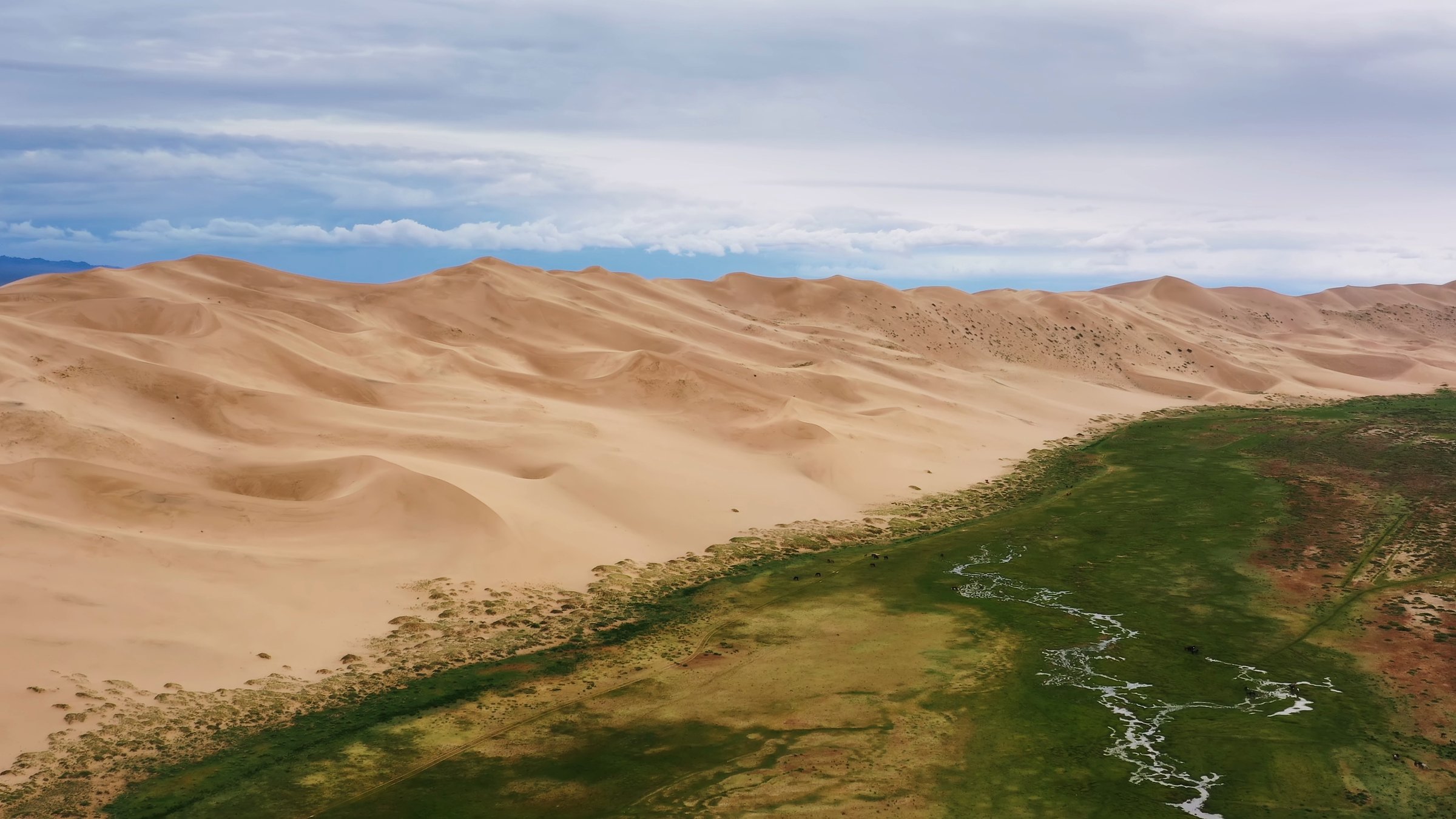 Aerial view on sand dunes under a gloomy cloudy sky